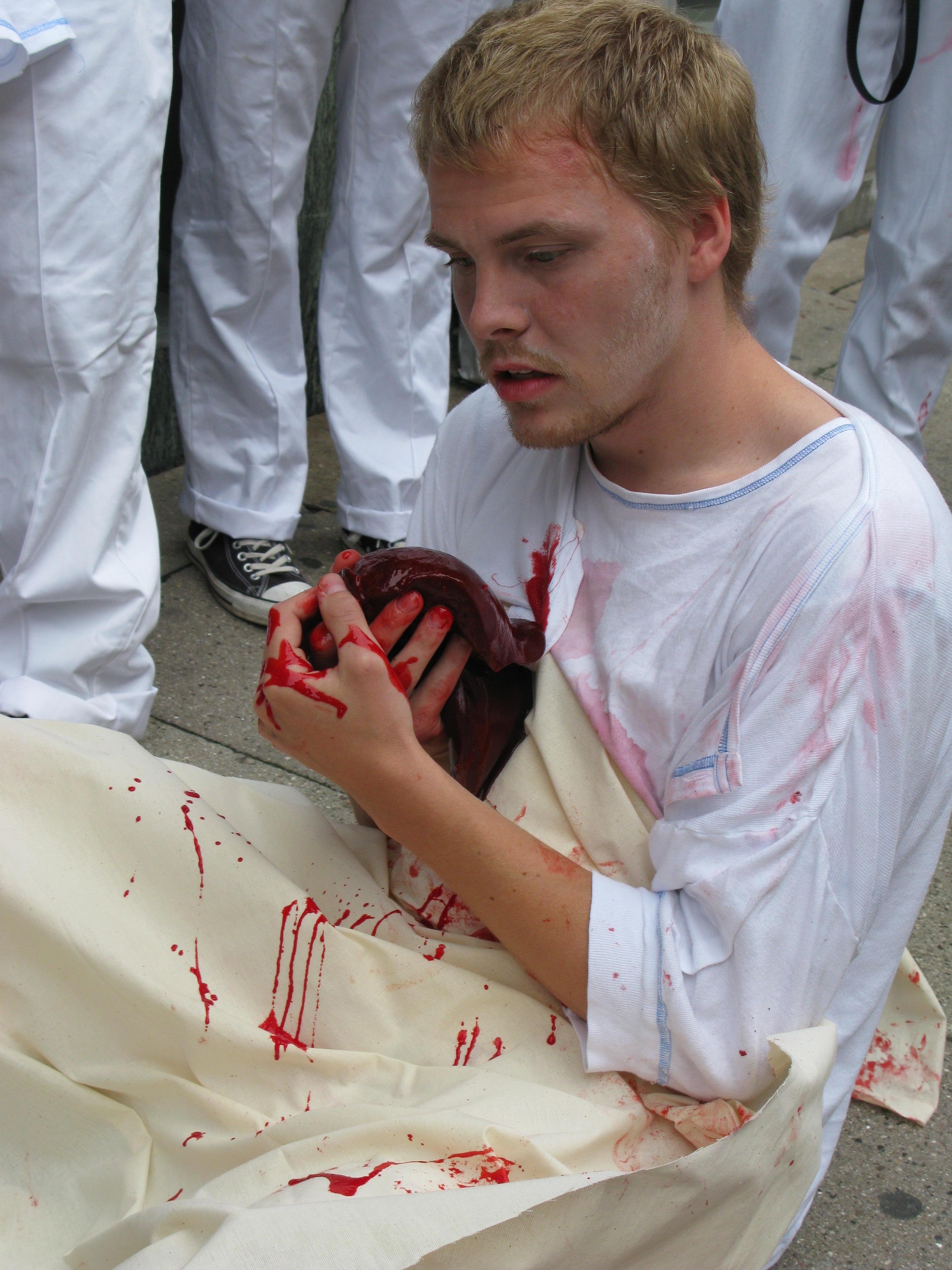 SPLATTERDEMO - En fejlbehandlet patient knuger sin lever på fortovet foran Videnskabsministeriet. Hvis Helge Sander ikke afsætter flere penge til lægestudiet, bliver dette resultatet, advarede de demonstrerende studerende.