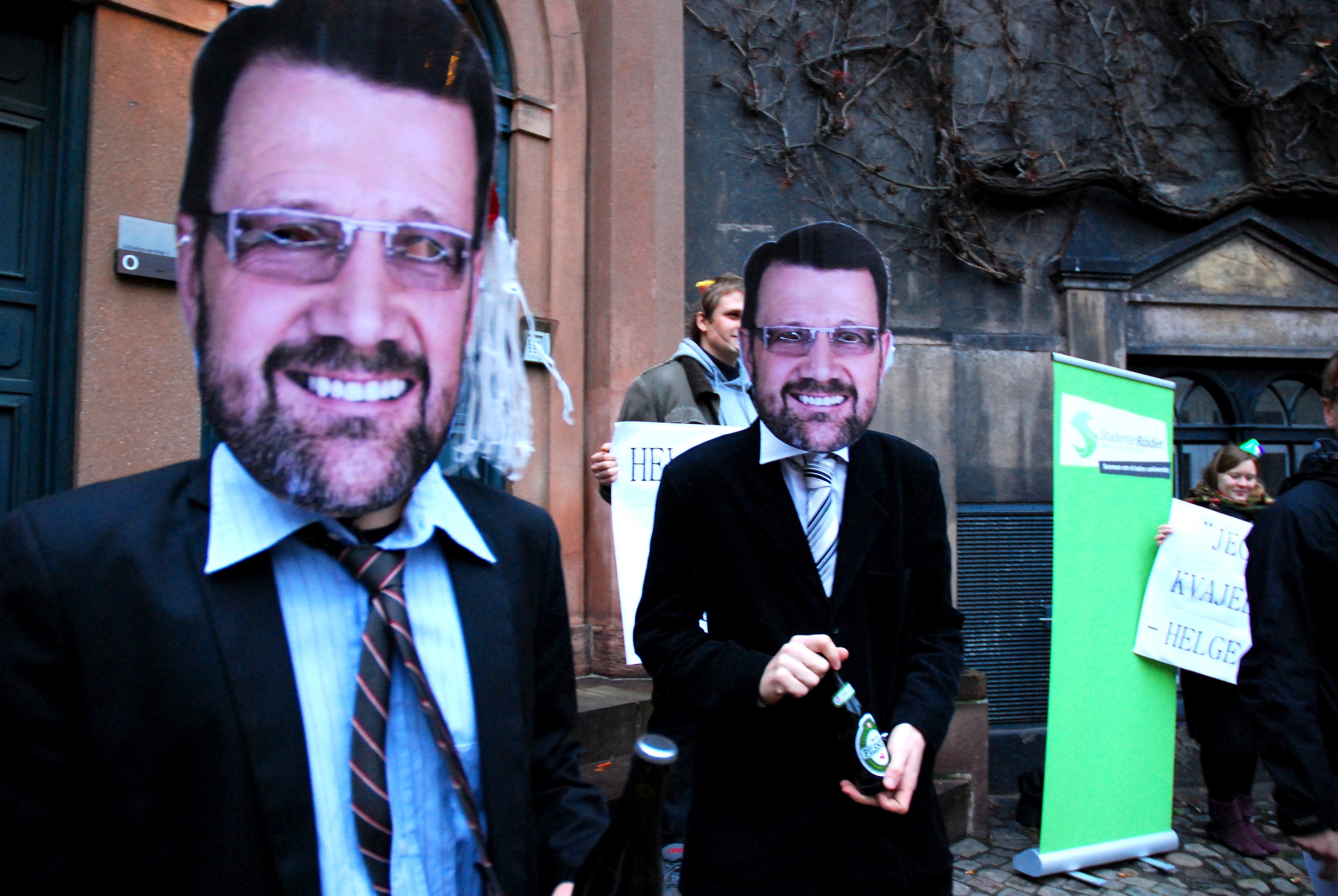 Protesters disguised as Minister of Science Helge Sander handing out beer and blame at university board meeting