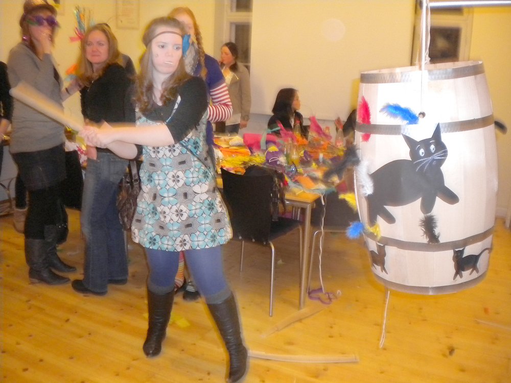 Elyse Shelley (Australia) takes a whack at the cat in the barrel, hoping to be crowned Cat Queen.
