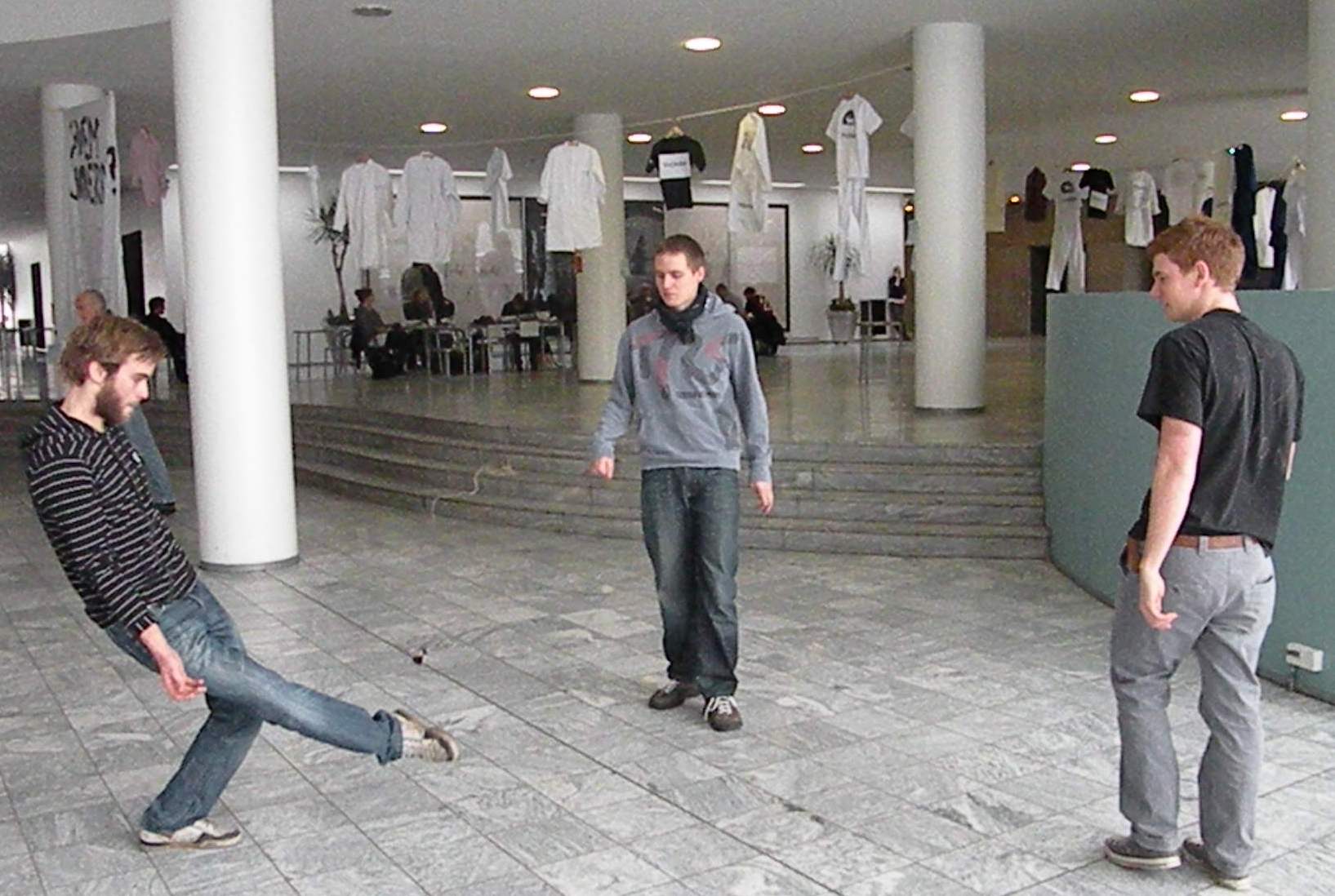 STUDENTERLEG - Studerende spiller 'hacky sack' på Life. I baggrunden hænger trøjerne fra DSR´s event, der skulle gøre opmærksom på de aktuelle besparelser.