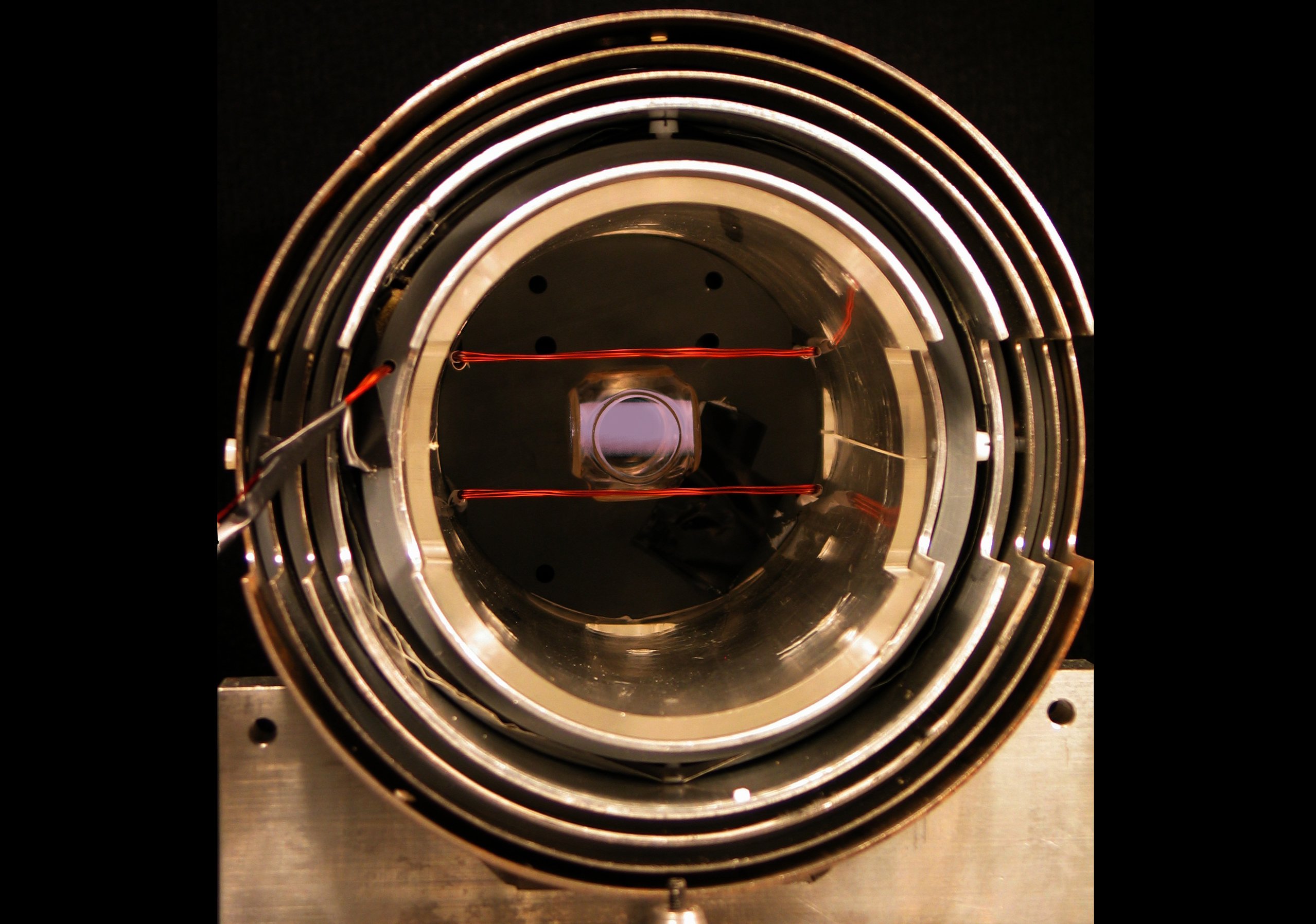 Central part of the magnetometer. The glowing object in the centre is the glass cell with atoms, used to probe the magnetic field. The cell is placed inside a triple-layer magnetic shield, protecting it from external magnetic fields