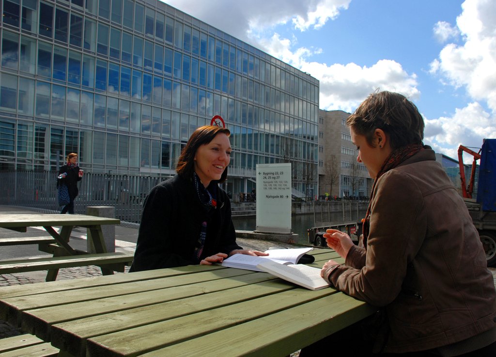 Two humanities students, Marie and Lea, take their books outside at KUA, on Amager 