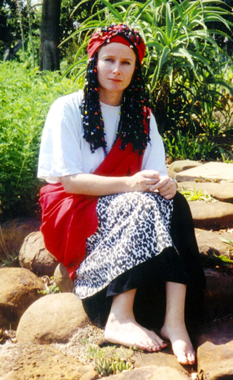 Anna Jäger på et foto under sit studie- og arbejdsophold i zululand siddende i en thwasa-dragt, som er den dragt som en type af healere, sangoma, i Sydafrika bærer som lærlinge, i medicinplantehaven ved University of KwaZulu-Natal i 2001 i Sydafrika, hvor hun boede i ni år fra 1993-2002. 