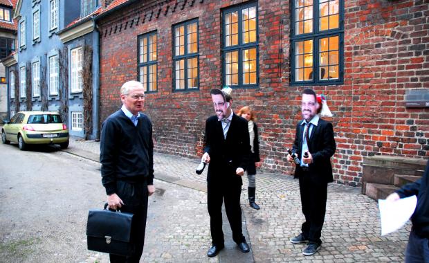 DRAMATISK MØDE - Claus Bræstrup talte også imod afskedigelser, da bestyrelsen skulle godkende budgettet for 2010. Her bliver han tilbudt en kvajebajer af medlemmer af Studenterrådet iført Helge Sander-masker.