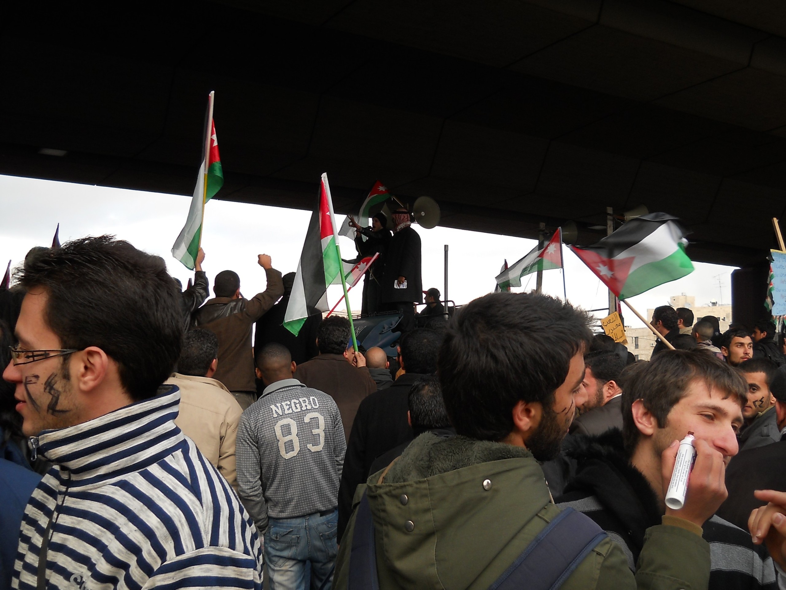 Members of 'the 24th of March Youth Movement' are preparing for the demonstration, writing '24' on one side of the face, and 'March' on the other. 