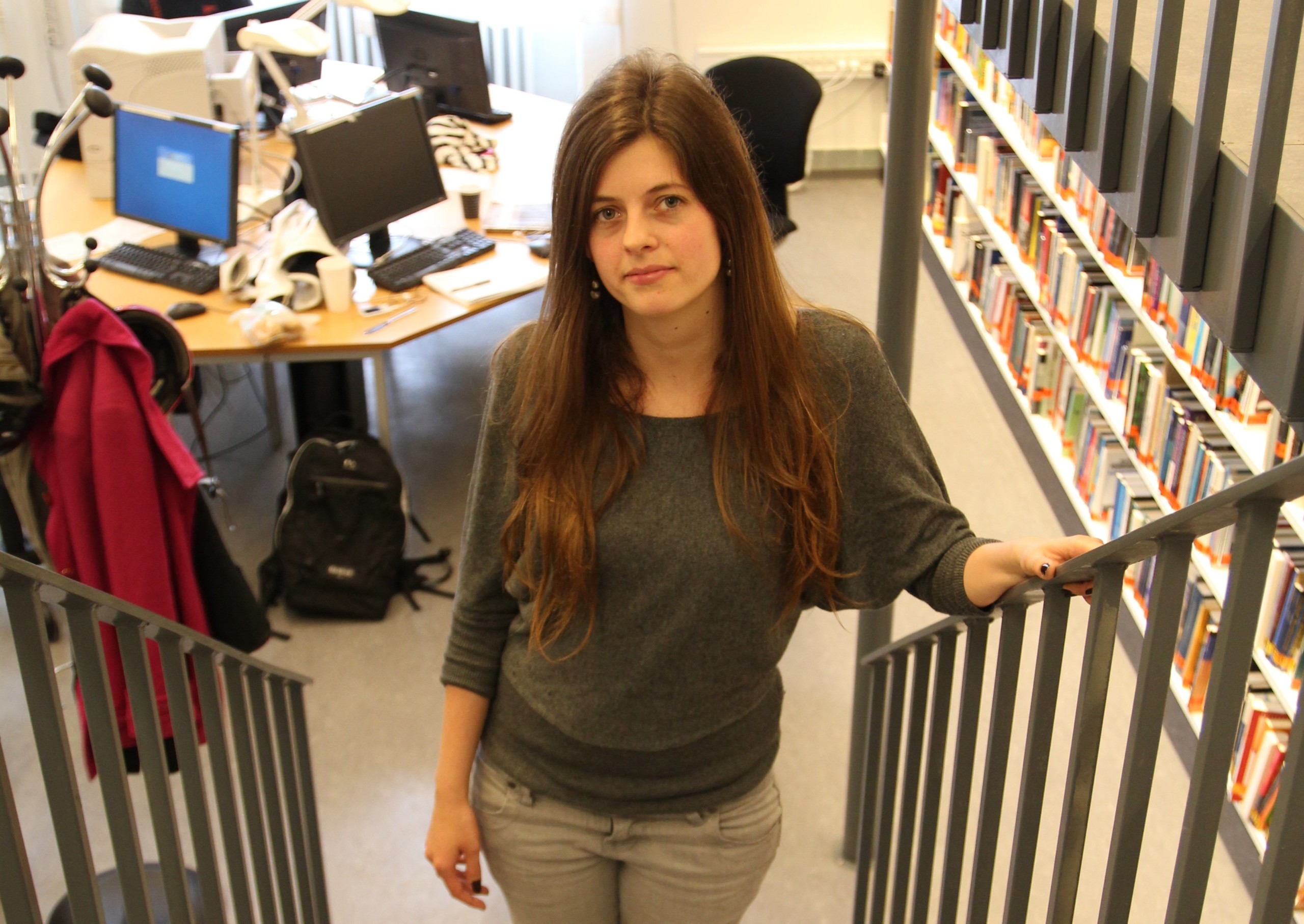 Political science student Kristine Hauge Bjergstrøm stands in her department library, one of five slated for closure