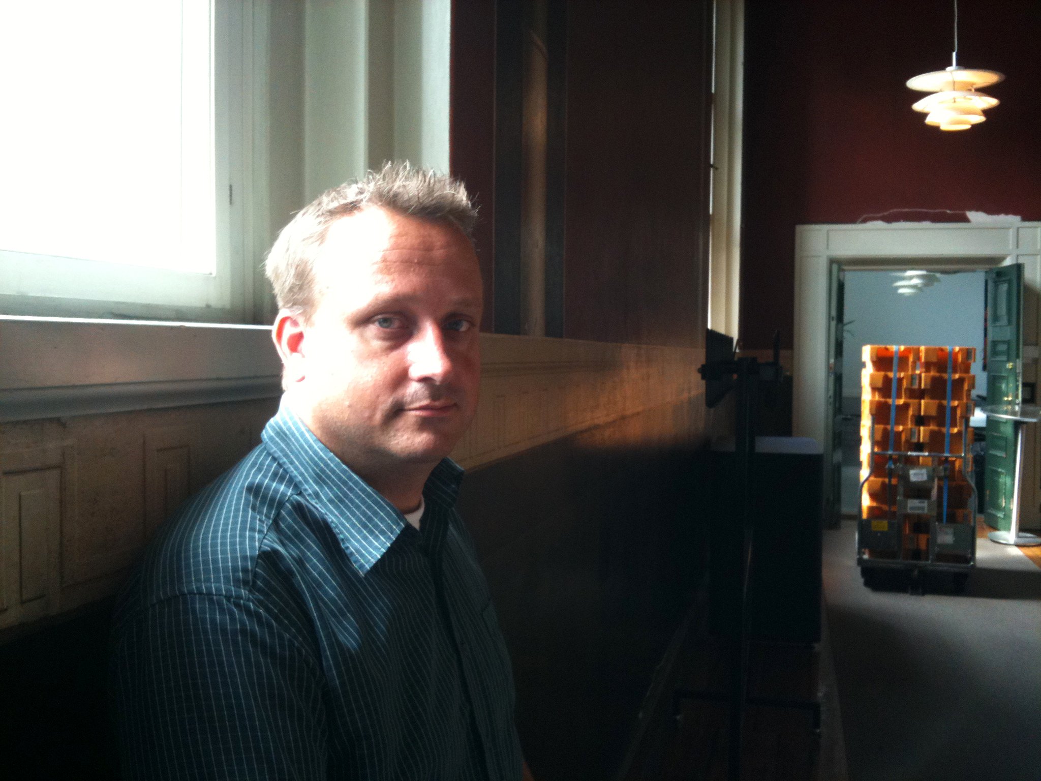 Head of Studies Claus Nielsen is happy with the University of Copenhagen's record high student numbers. Behind him are the stacks of welcoming letters. The picture is from Friday 29 June.