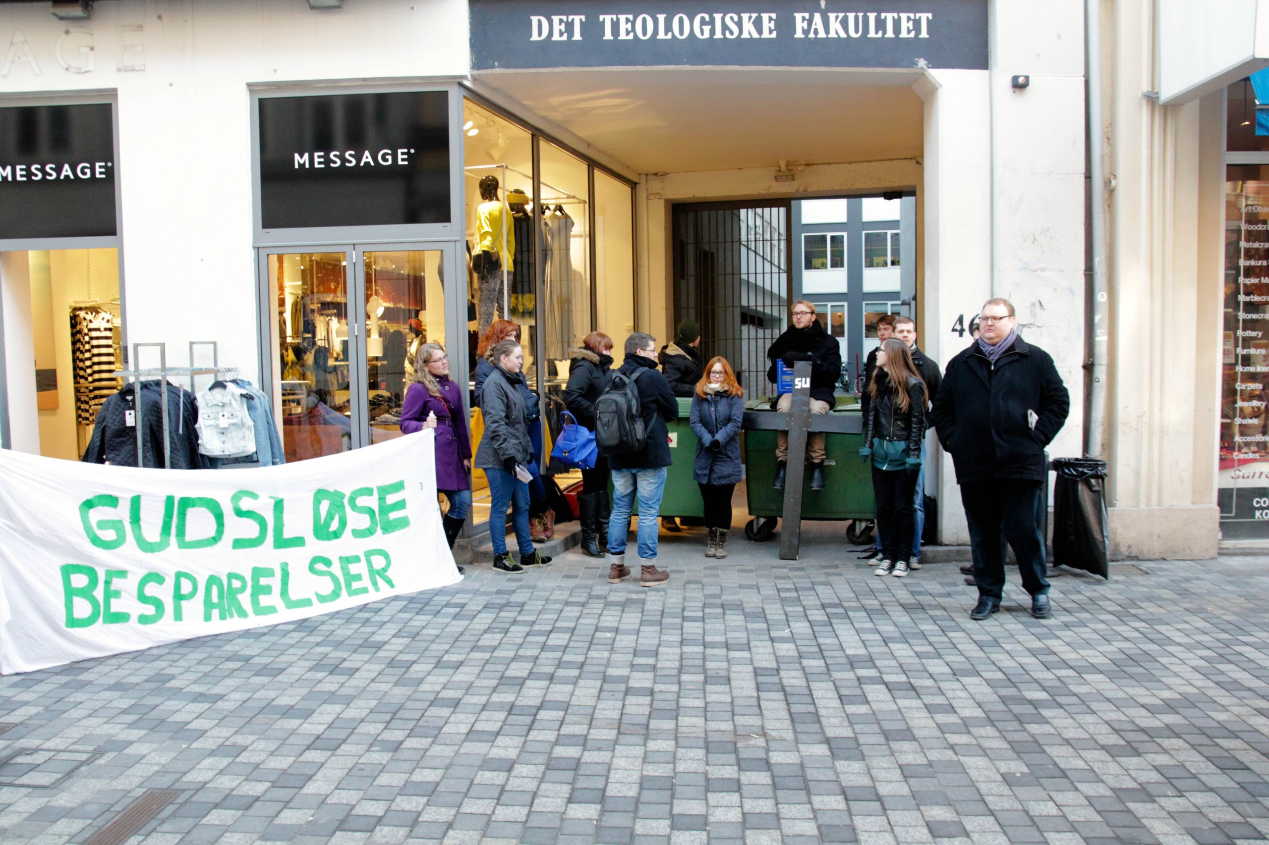 'Godless cutbacks' it says on the banner. The entrance is blocked with a cross with the sign 'SU' (study grants)