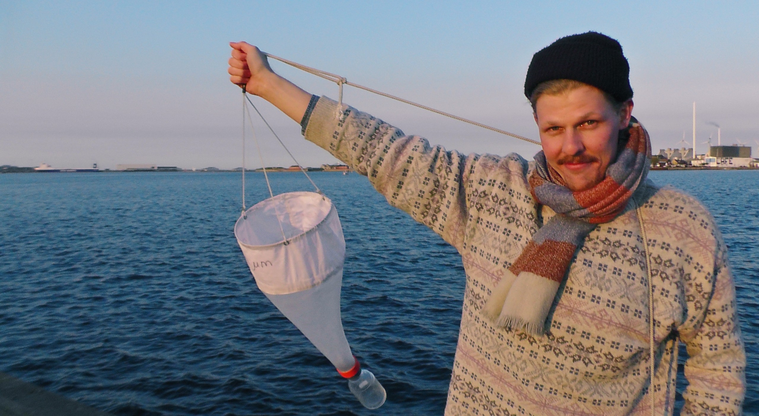 Jussi Nygren catches common jellyfish with a net in the Copenhagen harbour