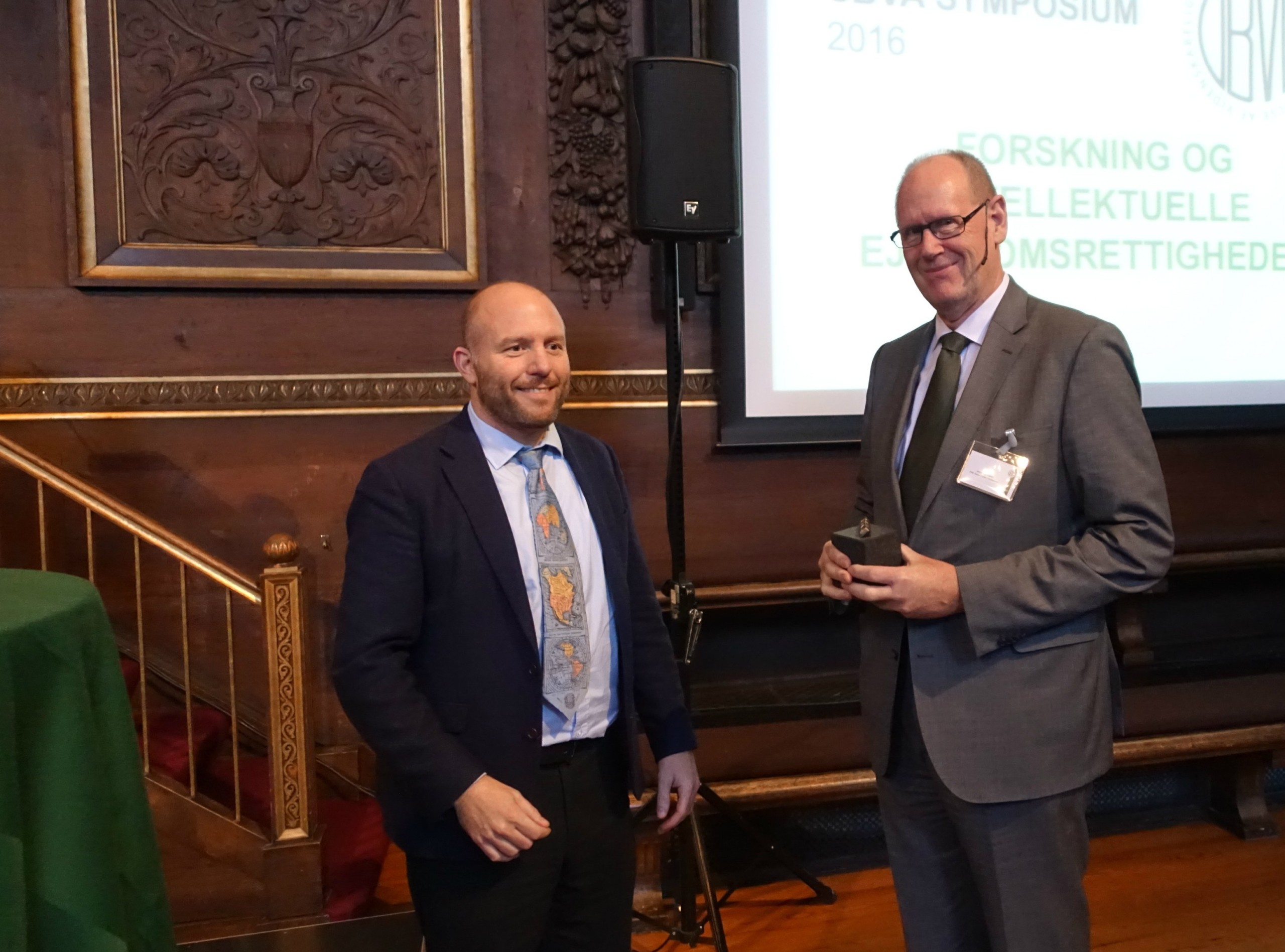 PRISOVERRÆKKELSE - Akademikernes formand, Lars Qvistgaard (t.v.), overrækker UBVA-prisen til adjungeret professor Jørgen Blomqvist (t.h.) i Københavns Universitets Festsal.