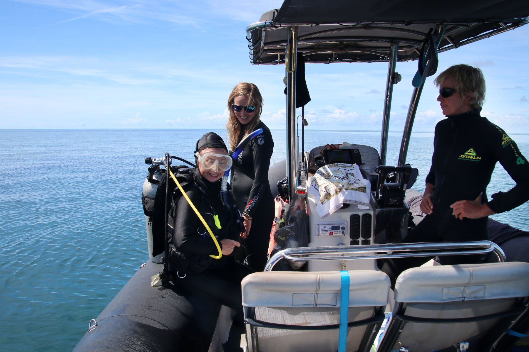 One of the research group's professors, Bette Willis, in the diving suit with her buddy diver in hand and with the ship's captain on the right.