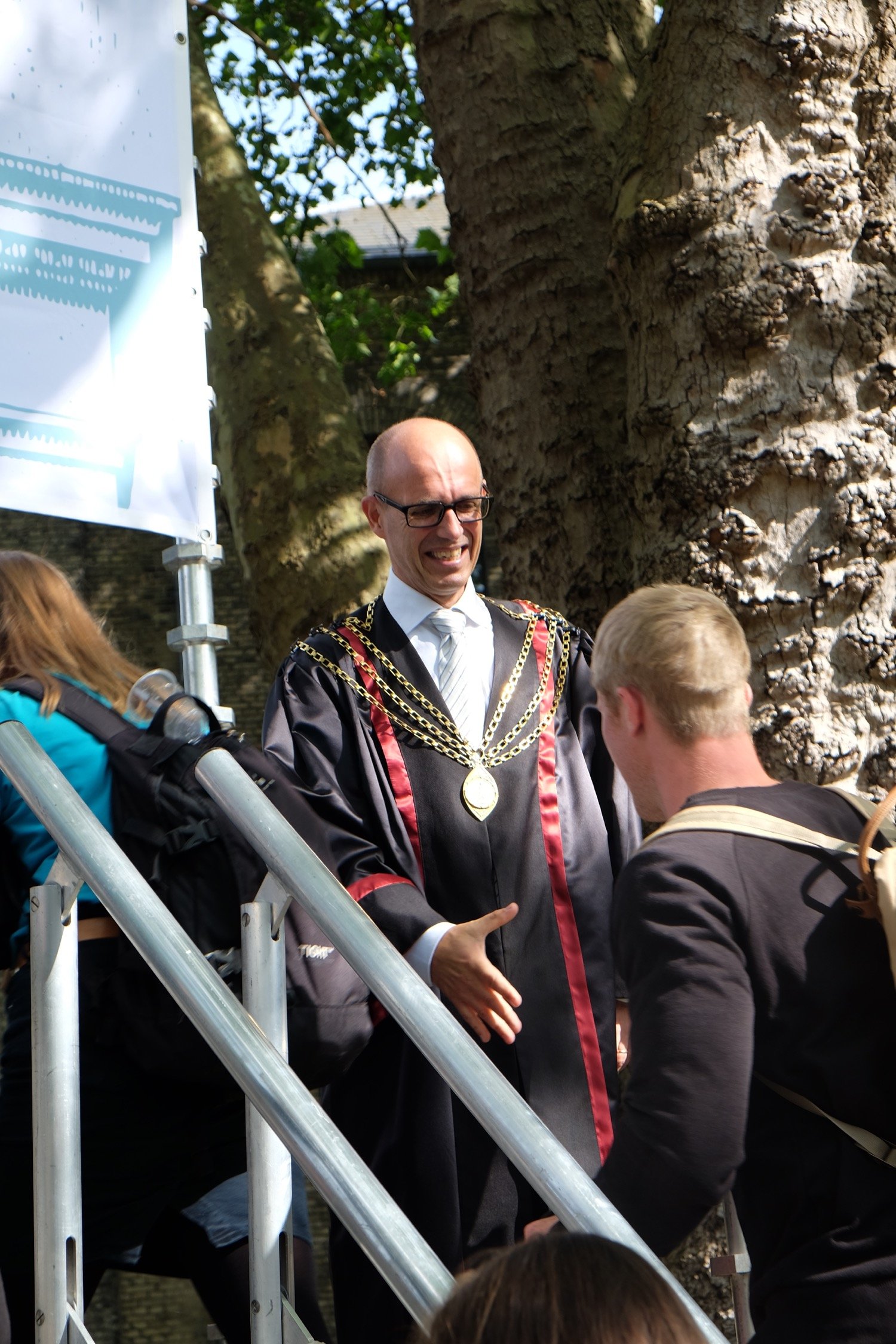 Med sådan en modtagelse, kan man da kun være i godt humør. En storsmilende Henrik C. Wegener giver hånd til en af de første studerende. 