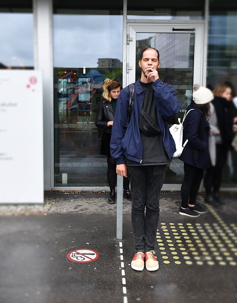 Lucas, der studerer religionsvidenskab, ryger på den tilladte side af KU's stiplede røggrænse ved Søndre Campus.