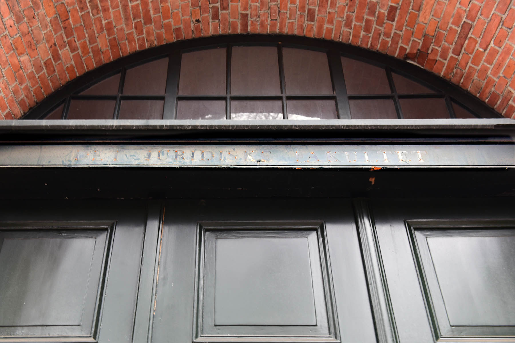 The outline of the Faculty of Law’s old sign can still be seen over the entrance to the Studiegaarden on Sankt Peders Stræde.