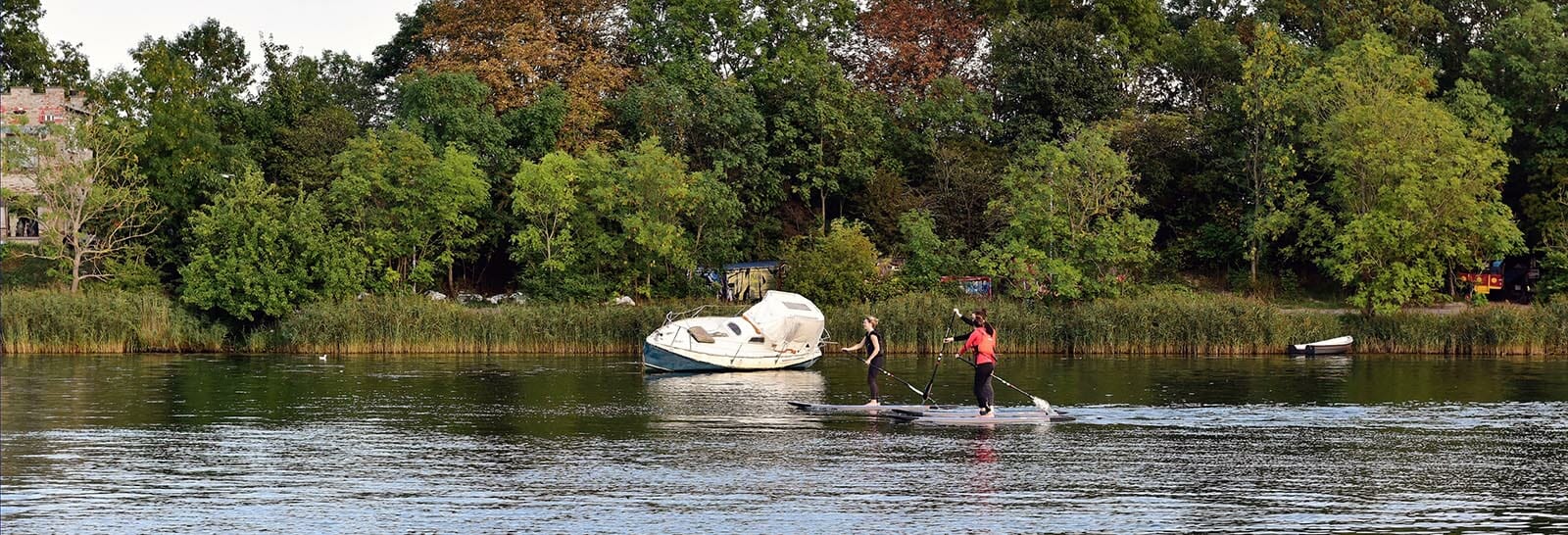 To øvede stand up paddlere glider forbi længere ude i kanalen