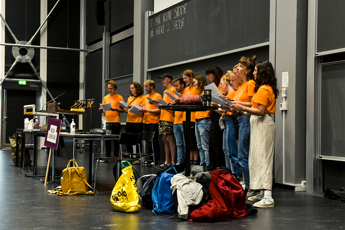 Tutorerne på Musikvidenskab byder russerne velkommen med firstemmig korsang – med mere end to meters afstand til deres publikum.