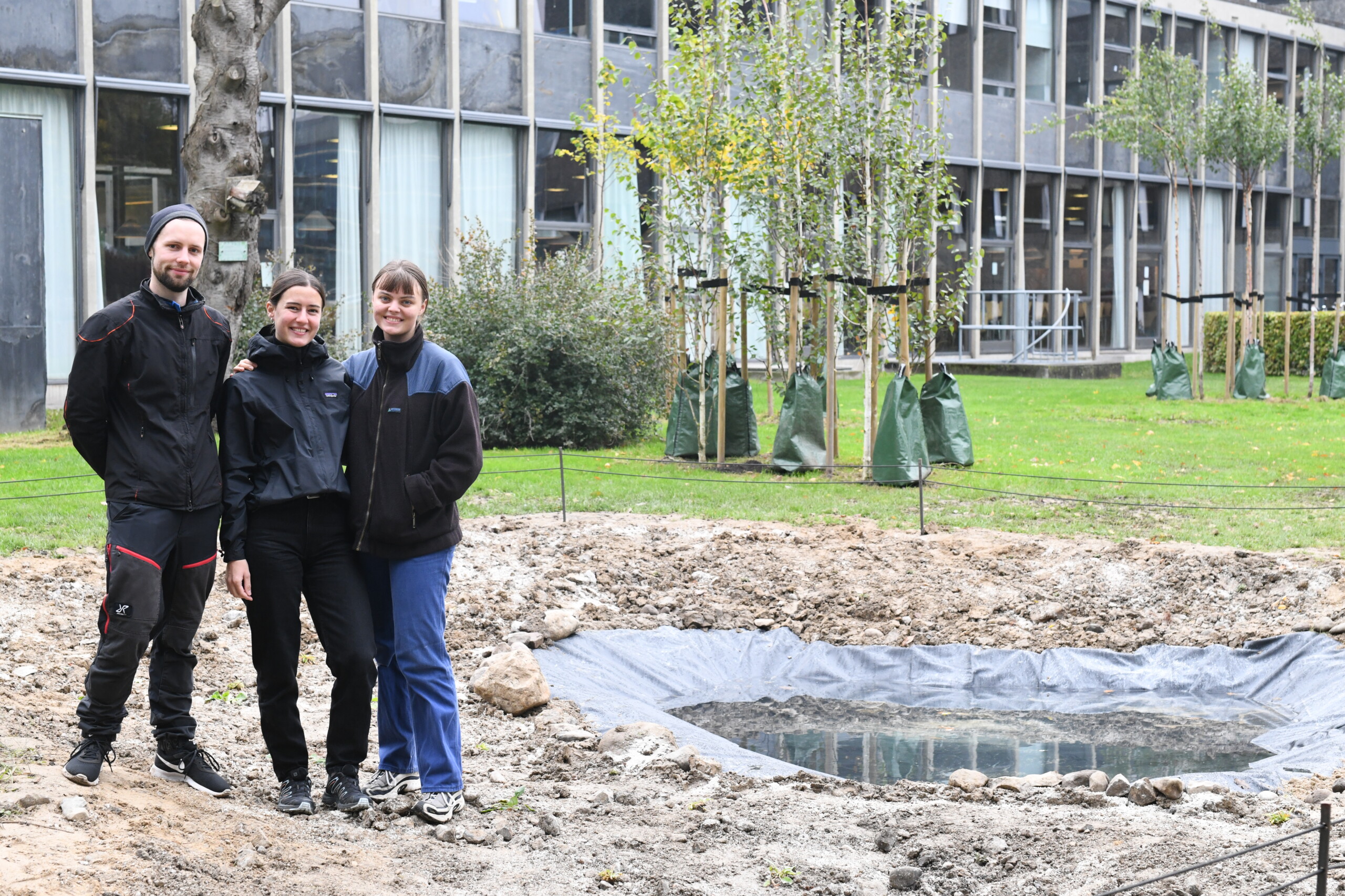 Her står Christian Revsbech Pedersen, Sophie Booker og Eva Schaldemose fra Vild Campus foran deres nygravede vandhul.