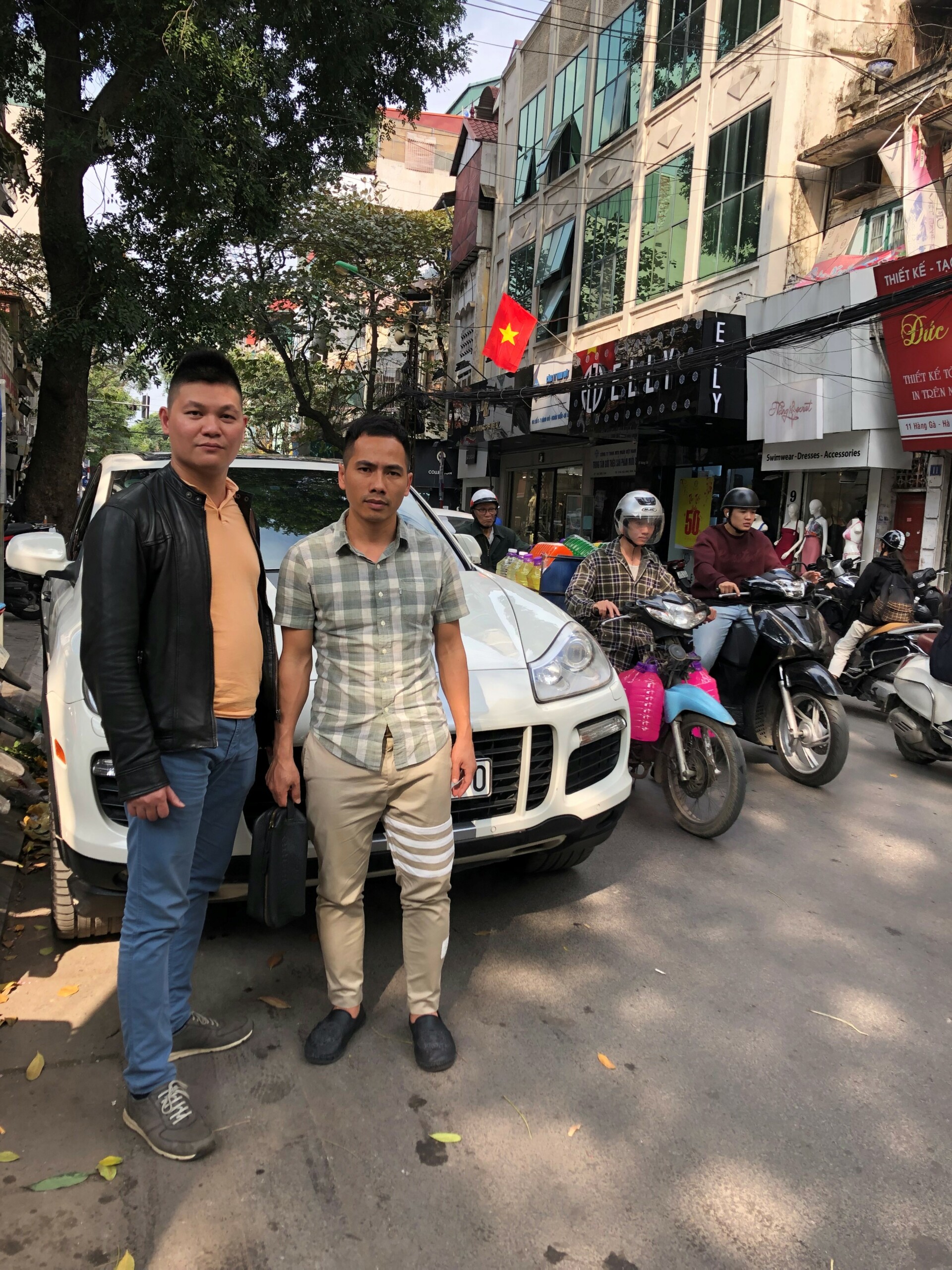 Dang Vu Hoai Nam (tv.) og hans forskningsassistent foran den Porsche, der var med til at skaffe forskerne adgang til de respondenter, de skulle bruge i deres projekt.