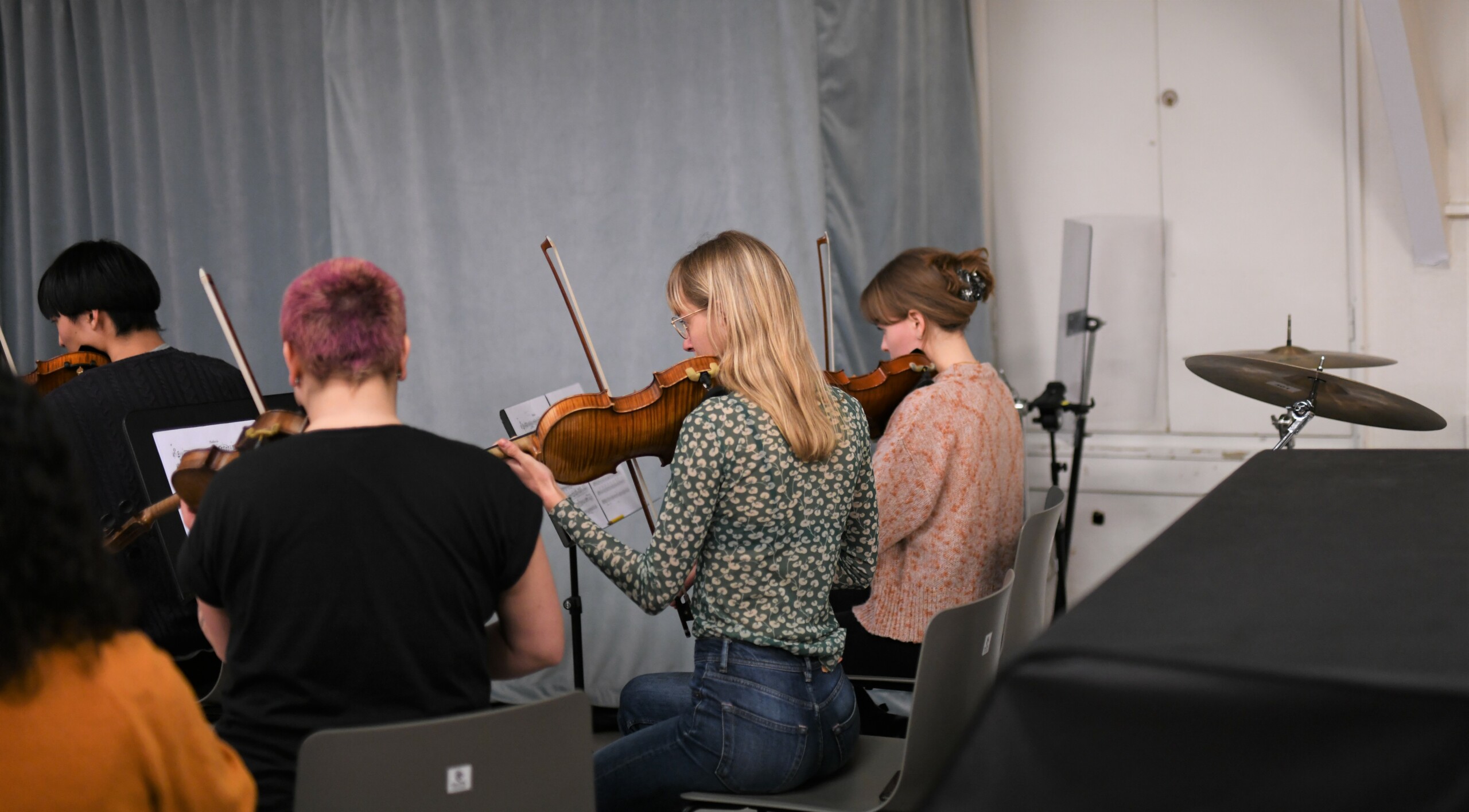 Orkesterets strygersektion er samlet i én side af rummet.