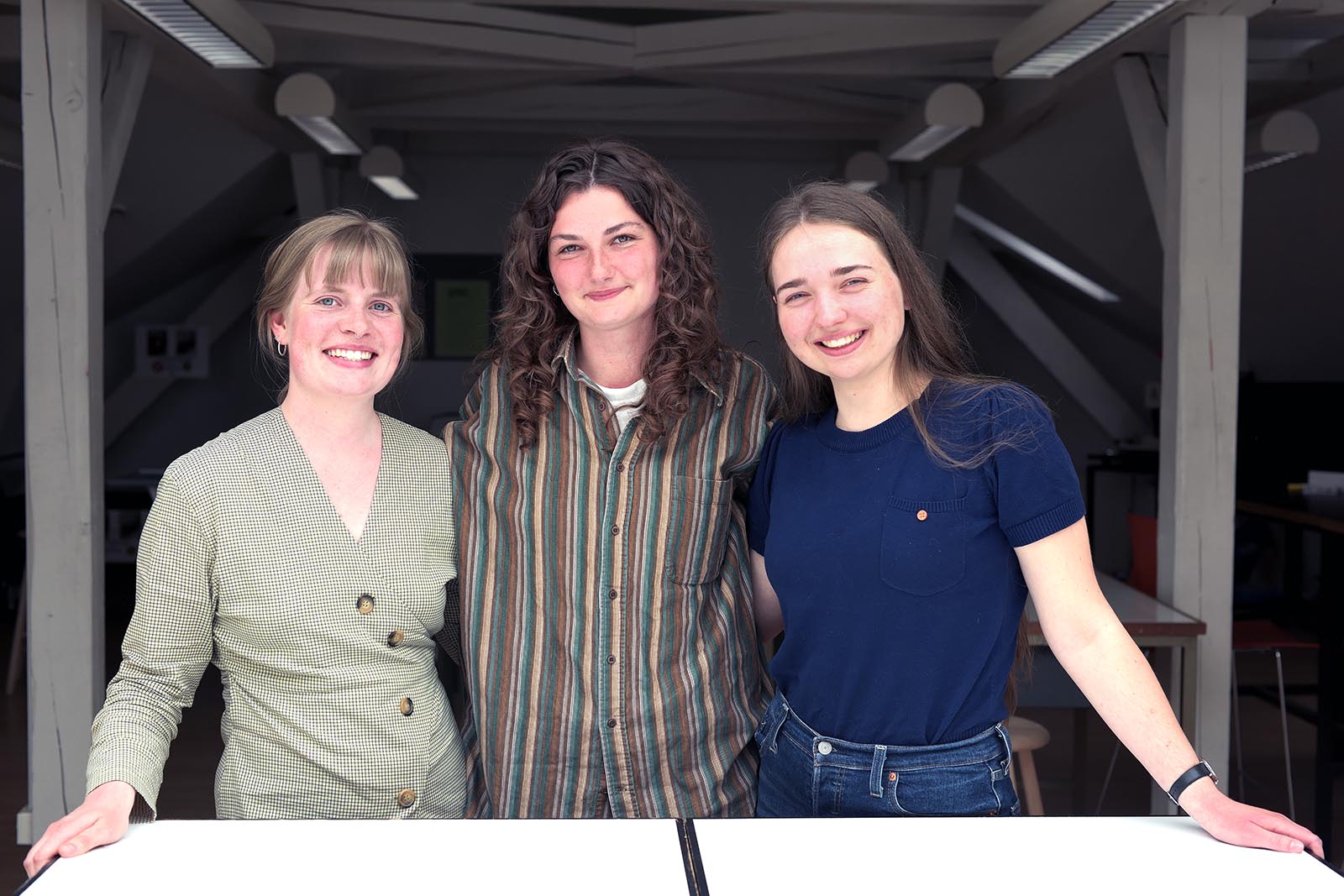 Fra venstre er det Simone Kejser, Ida Pedersen og Isabella Konge, der læser på en bachelor i landskabsarkitektur. Her står de under loftet i det øverste undervisningslokale på Institut for Geovidenskab, hvor Landskabsarkitektur har sine lokaler.