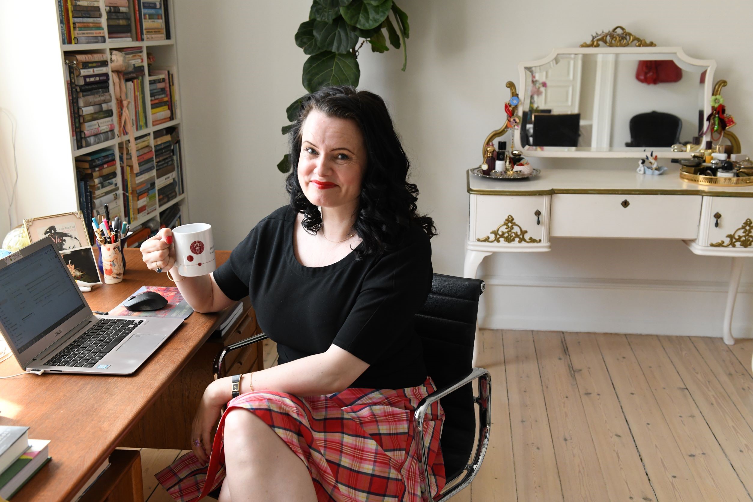 Leonora Christina Skov i sit arbejdsværelse, der er proppet med bøger. Skrivebordet står op mod et vindue, hvor hun har udsigt over Frederiksberg. 