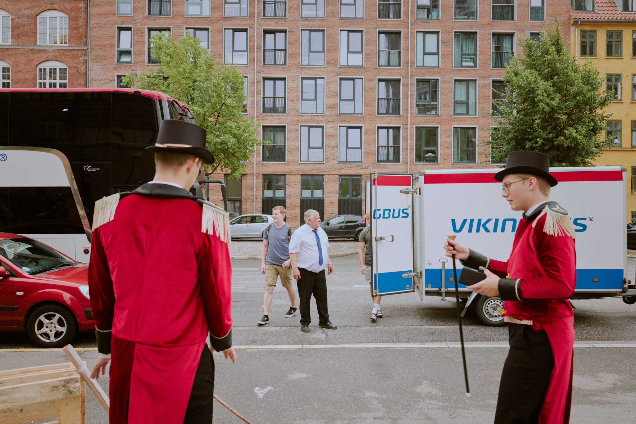 To cirkusdirektører styrer pålæsningen og det trafikale med stok og høj hat.