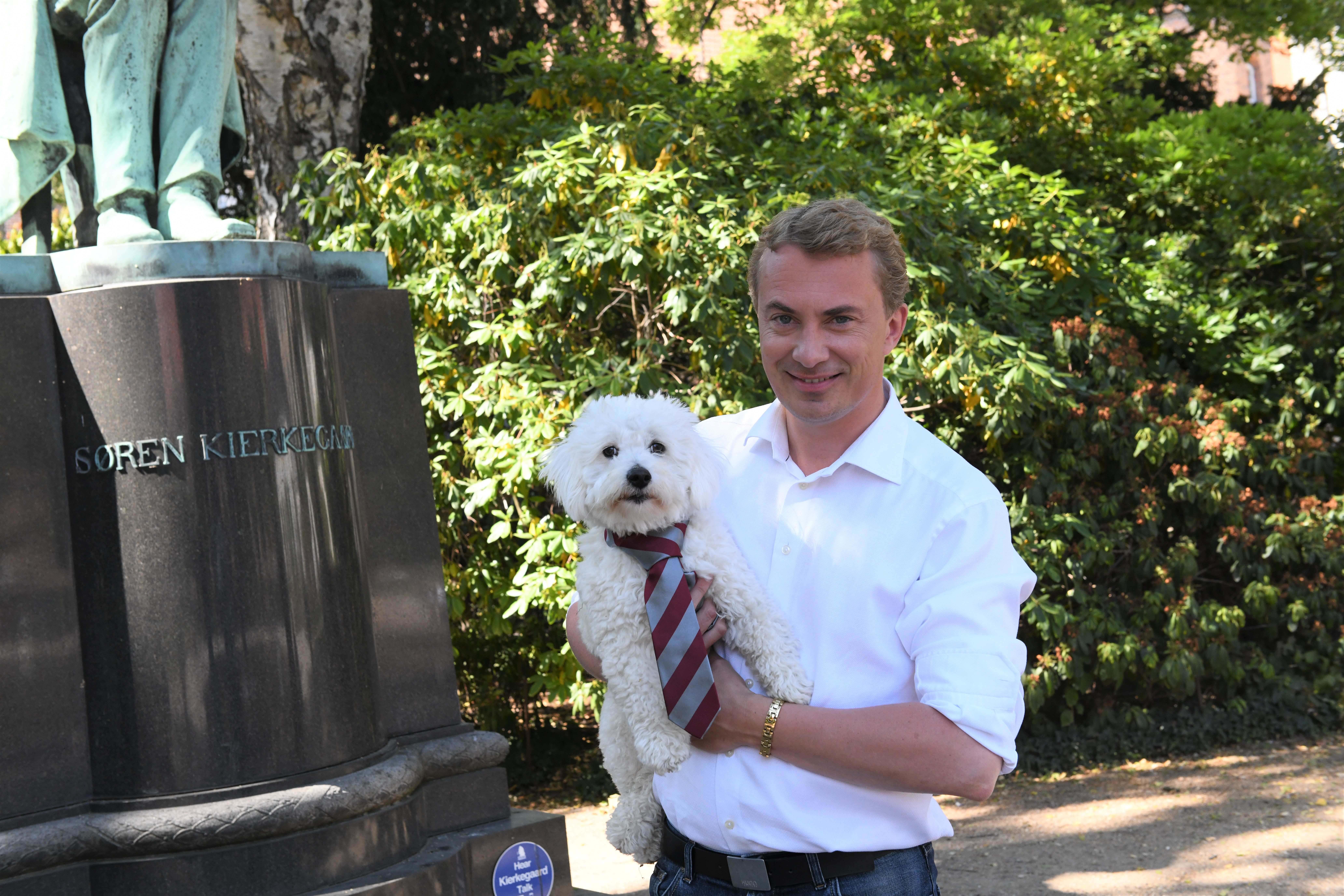 Morten Messerschmidt i Det Kongelige Biblioteks Have med sin hund, Hugo, der i dagens anledning er iført et KU-slips. 