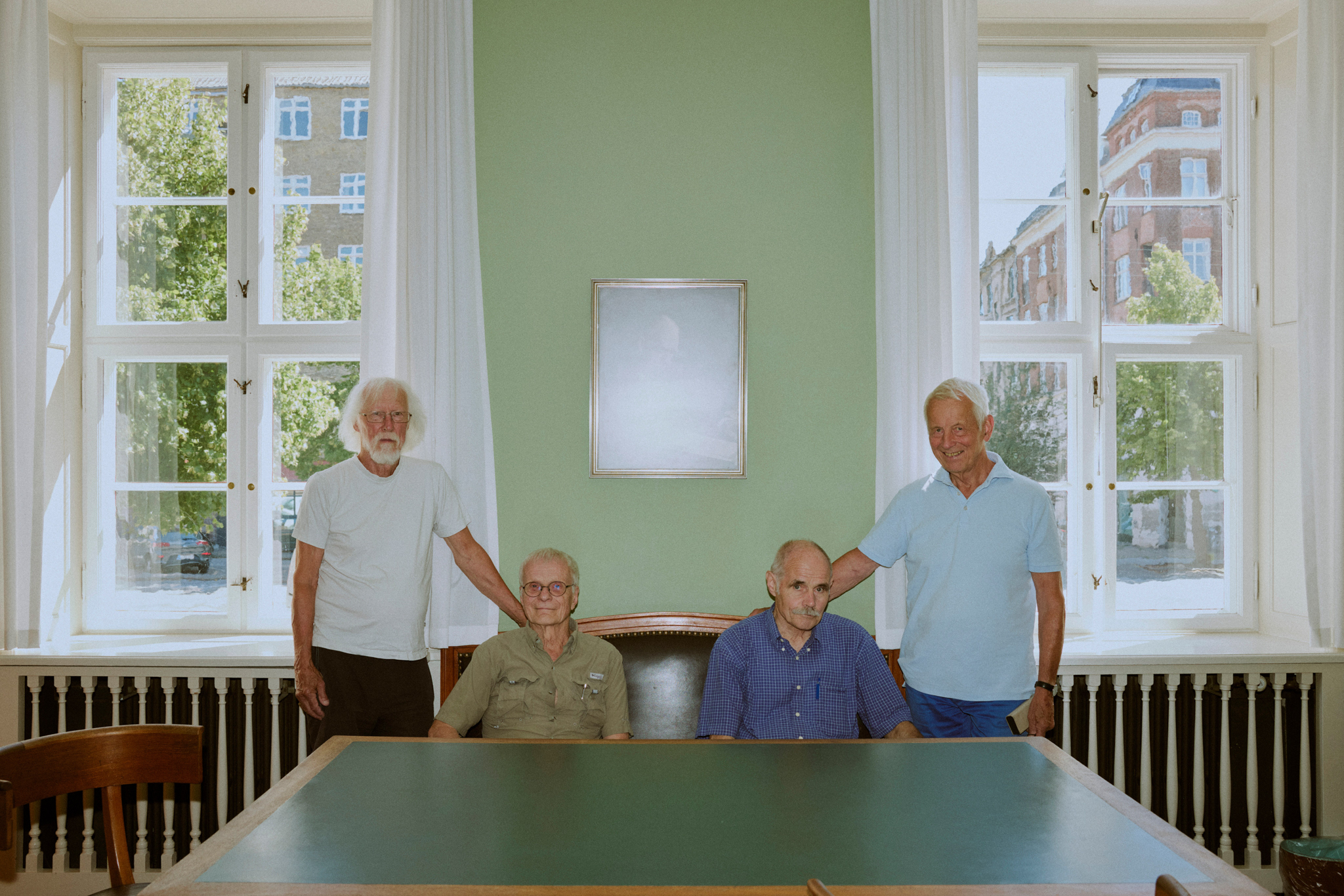 The four professors emeritus photographed behind the work table of Niels Bohr, which is in the intact original office on Blegdamsvej.