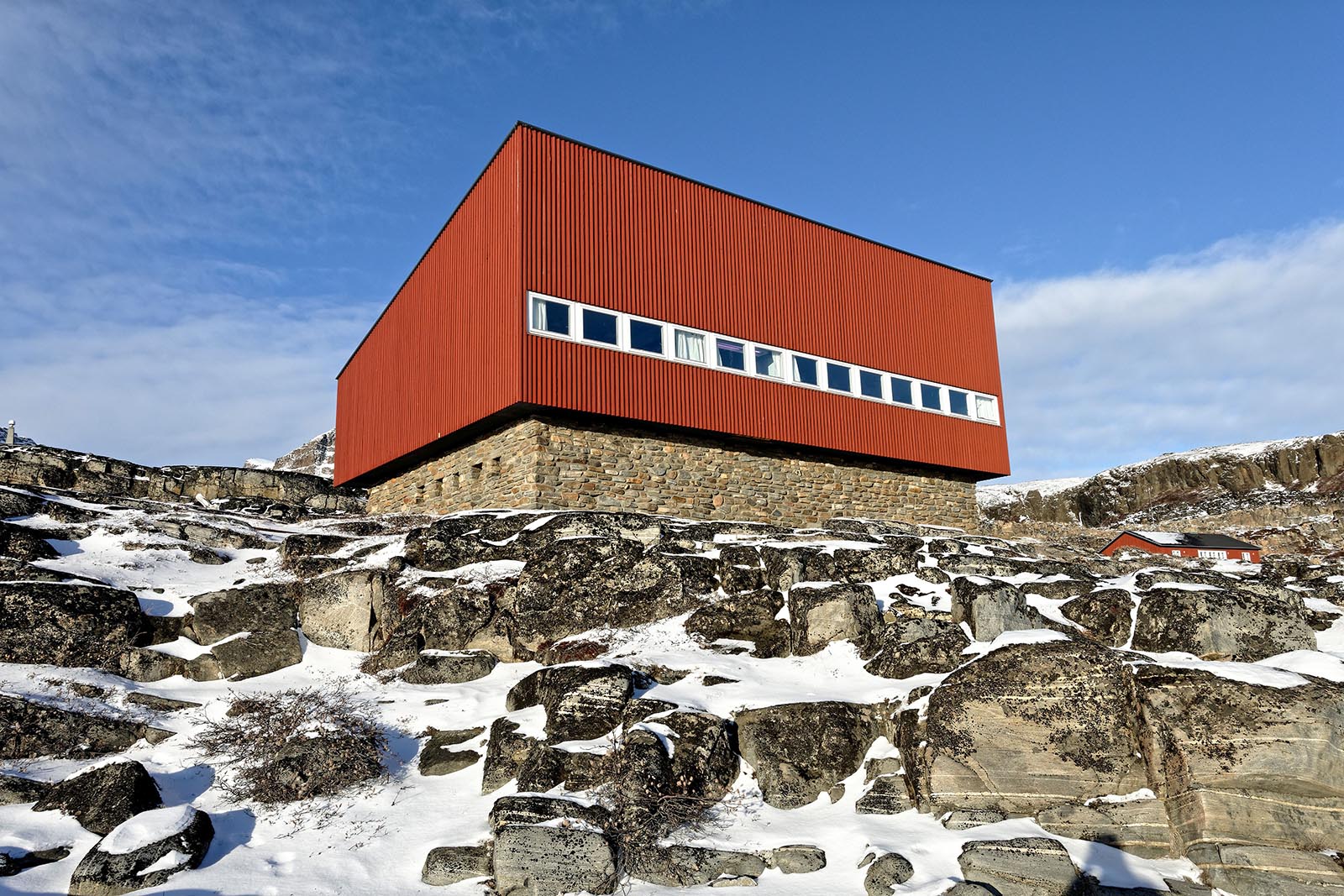 Den markante laboratoriebygning ligger cirka 150 meter vest for Arktisk Stations hovedbygning. Den røde overbygning indeholder bibliotek øverst og laboratorier i stuen. En voldsom snestorm i 2015 beskadigede konstruktionen til taget, og det var nødvendigt at udbedre skaderne, så det, der skulle blive til en renovering af hele Arktisk Station, begyndte der.