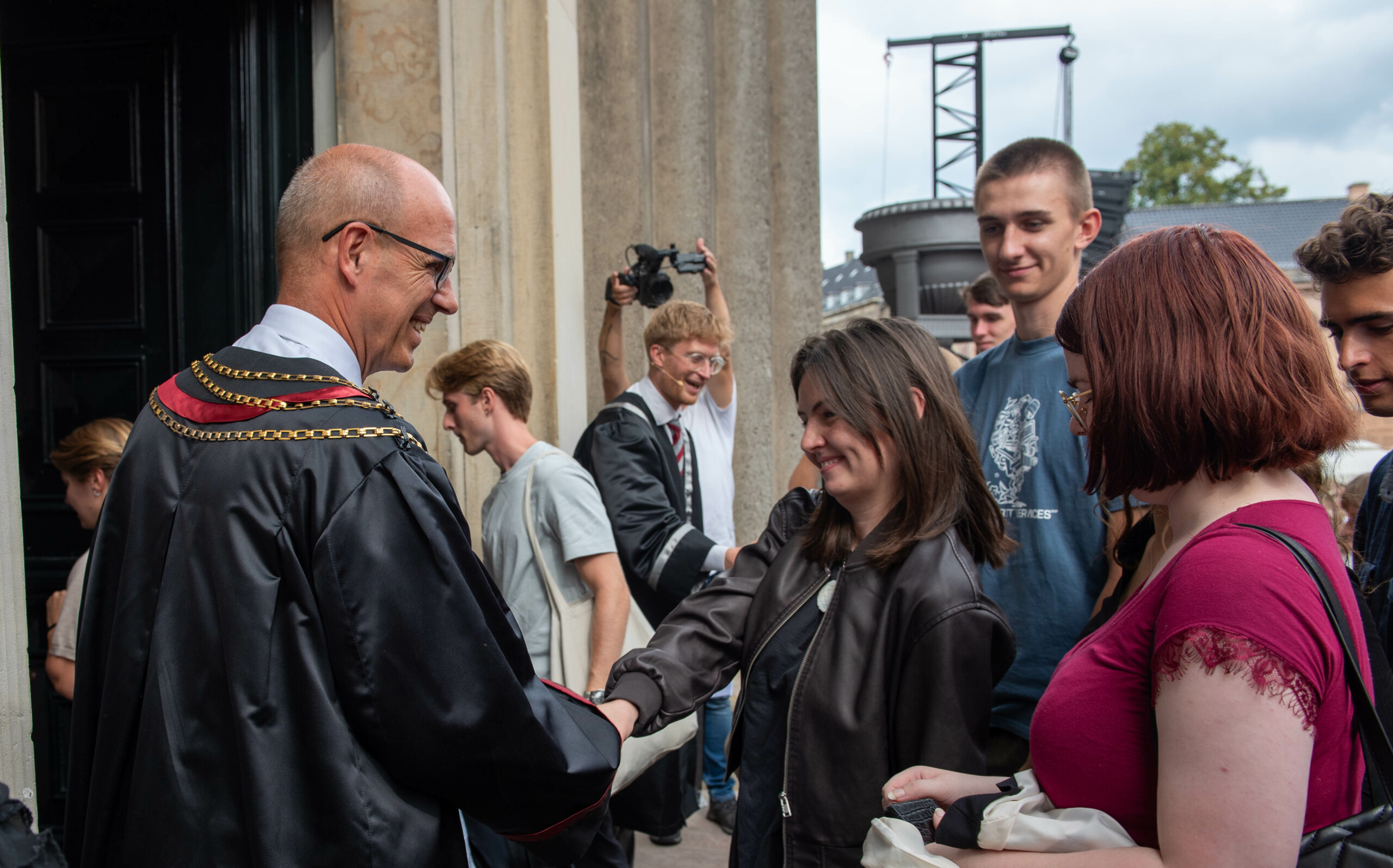  True to tradition, many students shook the hand of the robed rector Henrik C. Wegener (front, left) or Prorector for Education Kristan C. Lauta (centre).