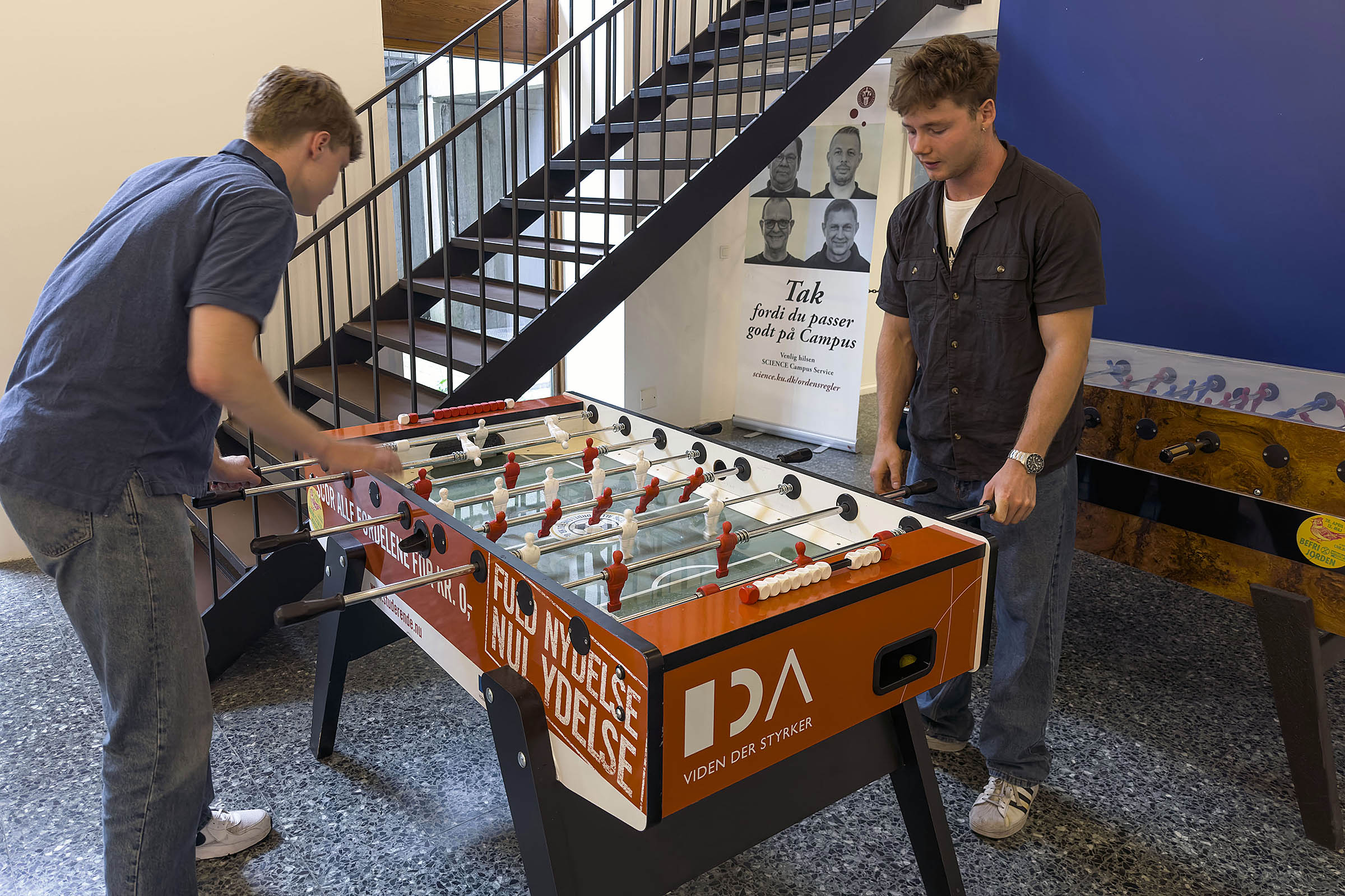 Her er vi i 'Katten' på City Campus: Spillere kan tage deres egen bold med, så de er sikre på at have det nødvendige til at kunne spille, men ofte står et bordfodboldbord nær en kantine eller en cafe, så det er muligt at købe sig til resten, man har brug for. 