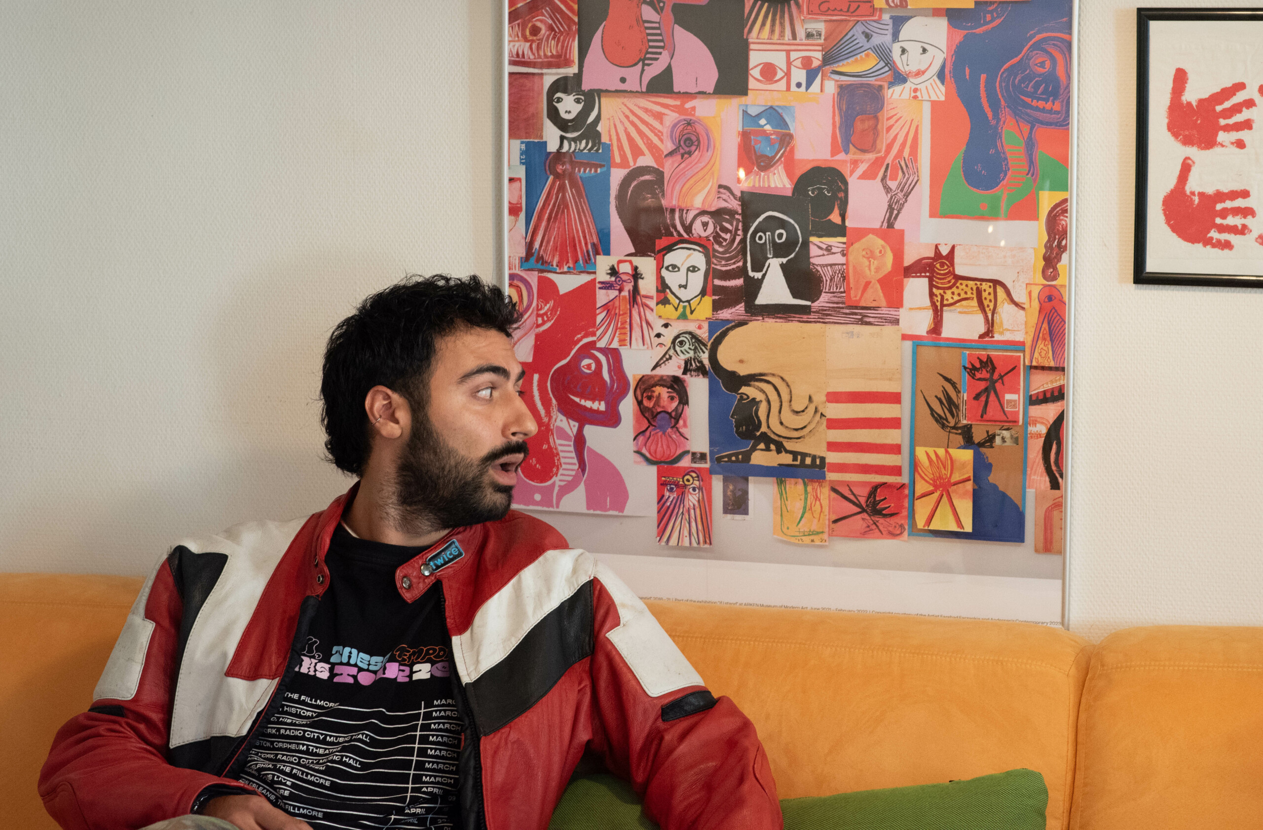 Nima Moradi i sin stue foran et værk af den dansk-iranske kunstner Farshad Farzankia.