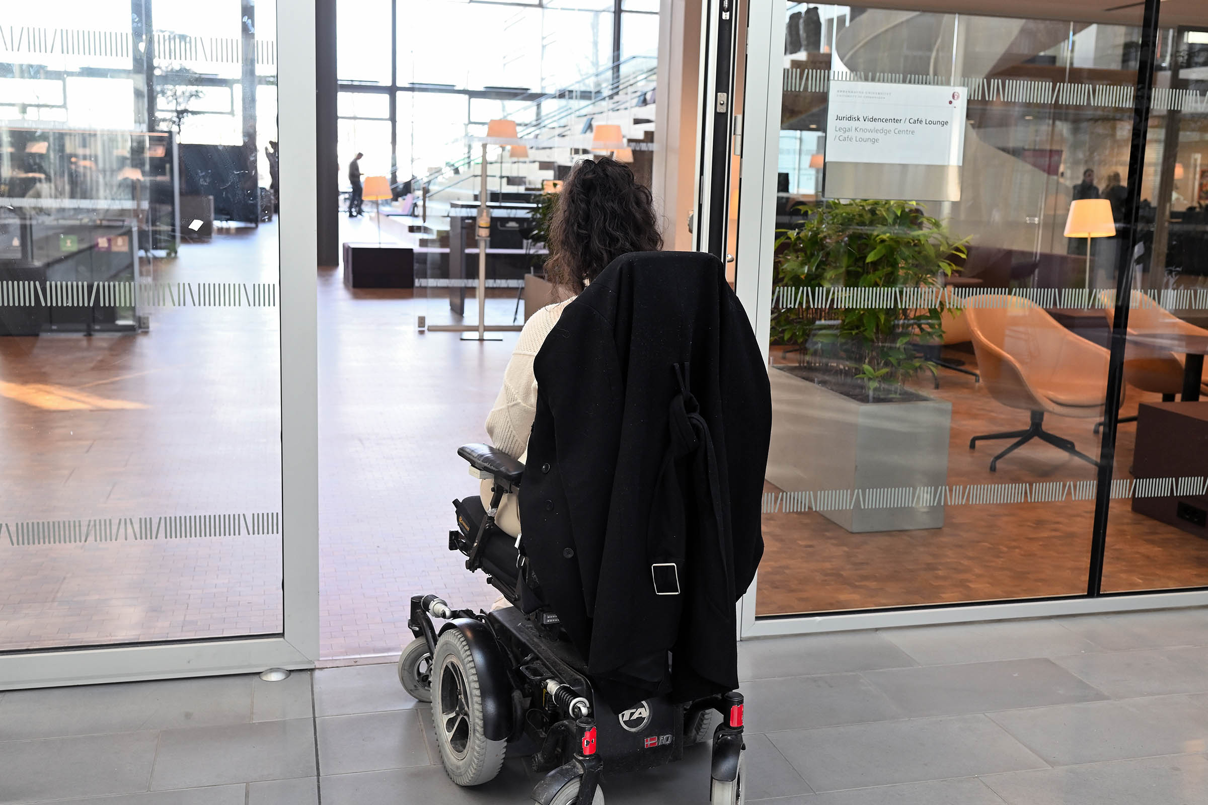 Det er nemt at trille ind i biblioteket. Der ingen forhindringer, og døren åbner af sig selv. Der er gjort meget for, at kørestolsbrugere er inkluderet på linje med alle andre studerende.