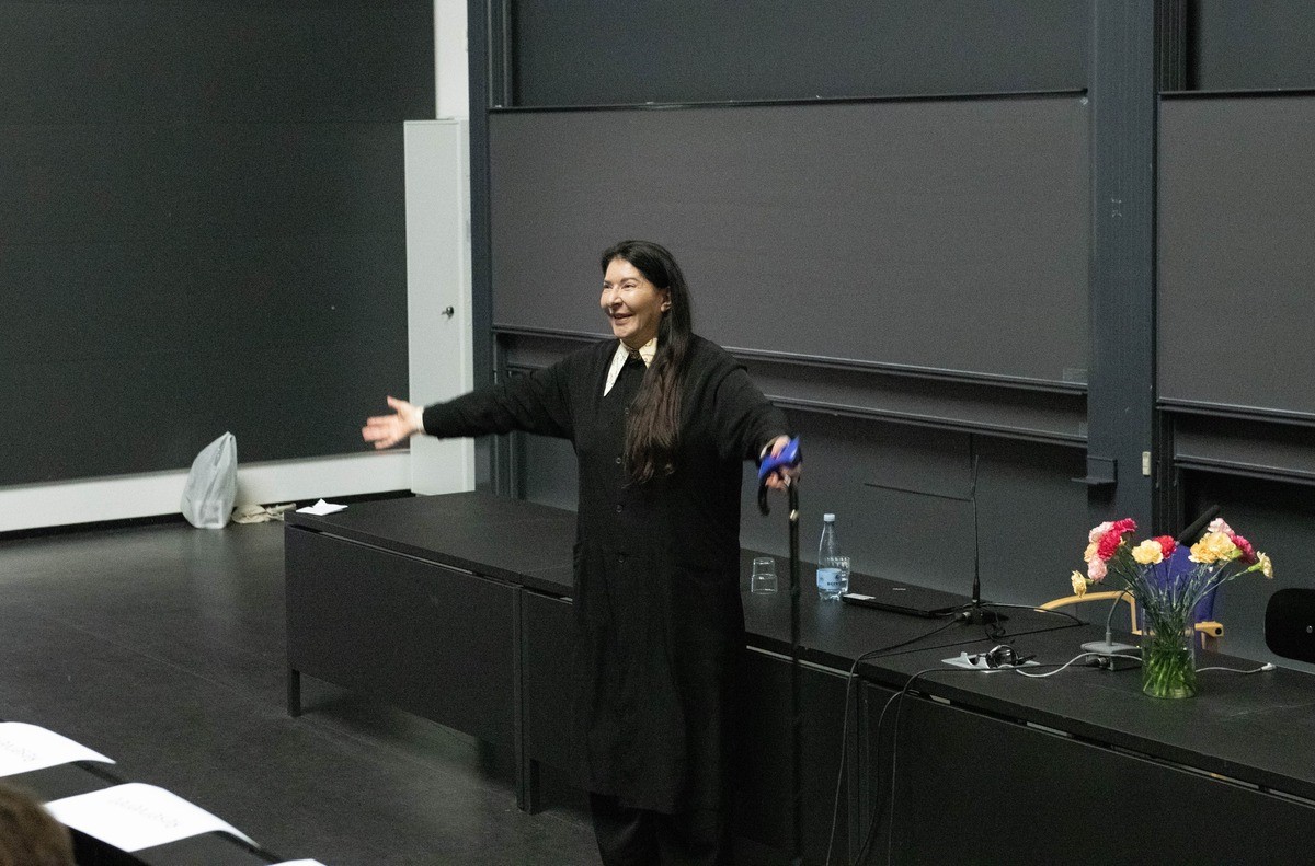Marina Abramović i en karateristisk gestus: I må spørge mig om alt, sagde hun, der især glædede sig til at høre, hvad de studerende havde på sinde.
