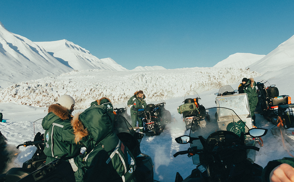 Studerende gør holdt ved en gletsjer på en firedages felttur på snescootere.