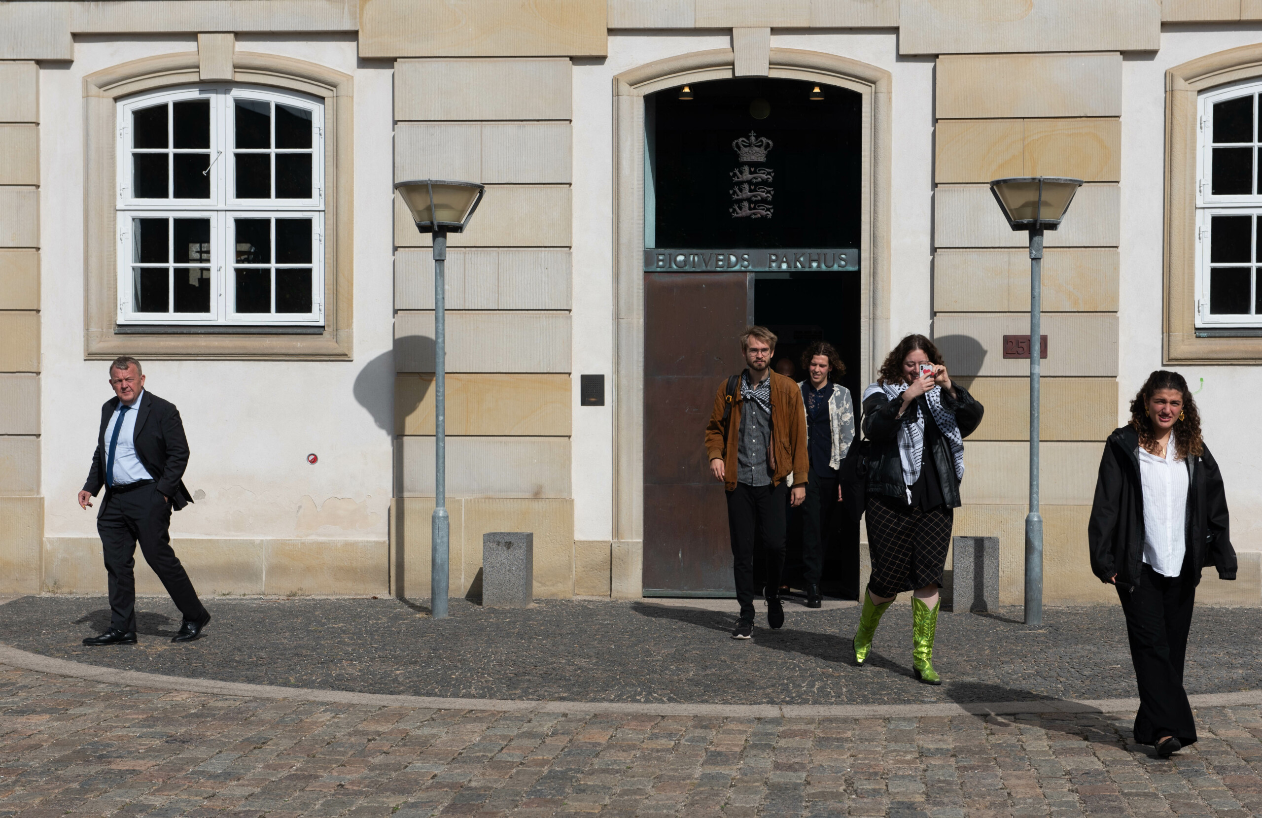 Udenrigsminister Lars Løkke Rasmussen (tv.) og de fire repræsentanter fra Studerende mod Besættelsen på vej ud fra mødet i Udenrigsministeriet.