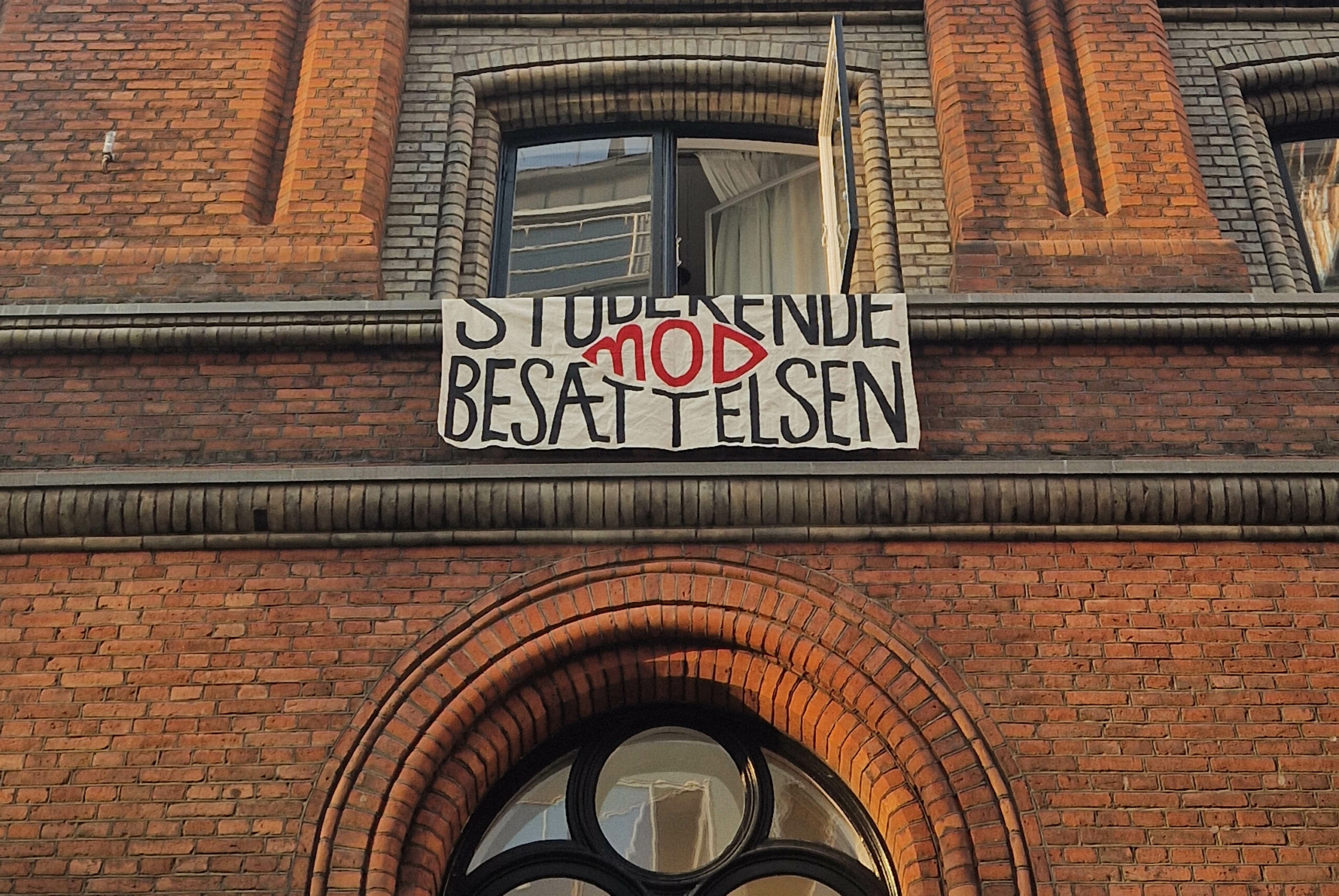 Studerende mod Besættelsens banner hænger ud ad et vindue i administrationsbygningen, efter bevægelsen har besat stedet onsdag den 4. september.