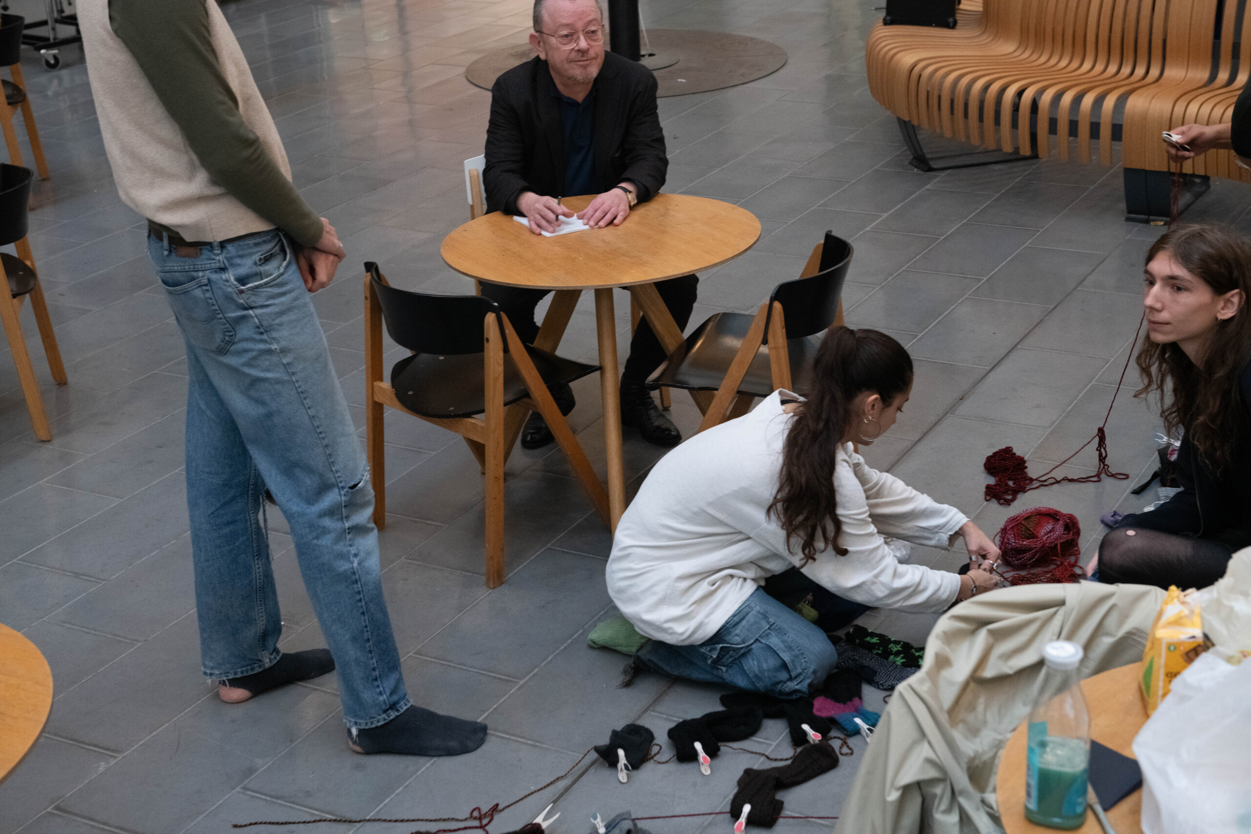 The faculty director is getting ready to write down names while the students start setting up garlands out of their socks.