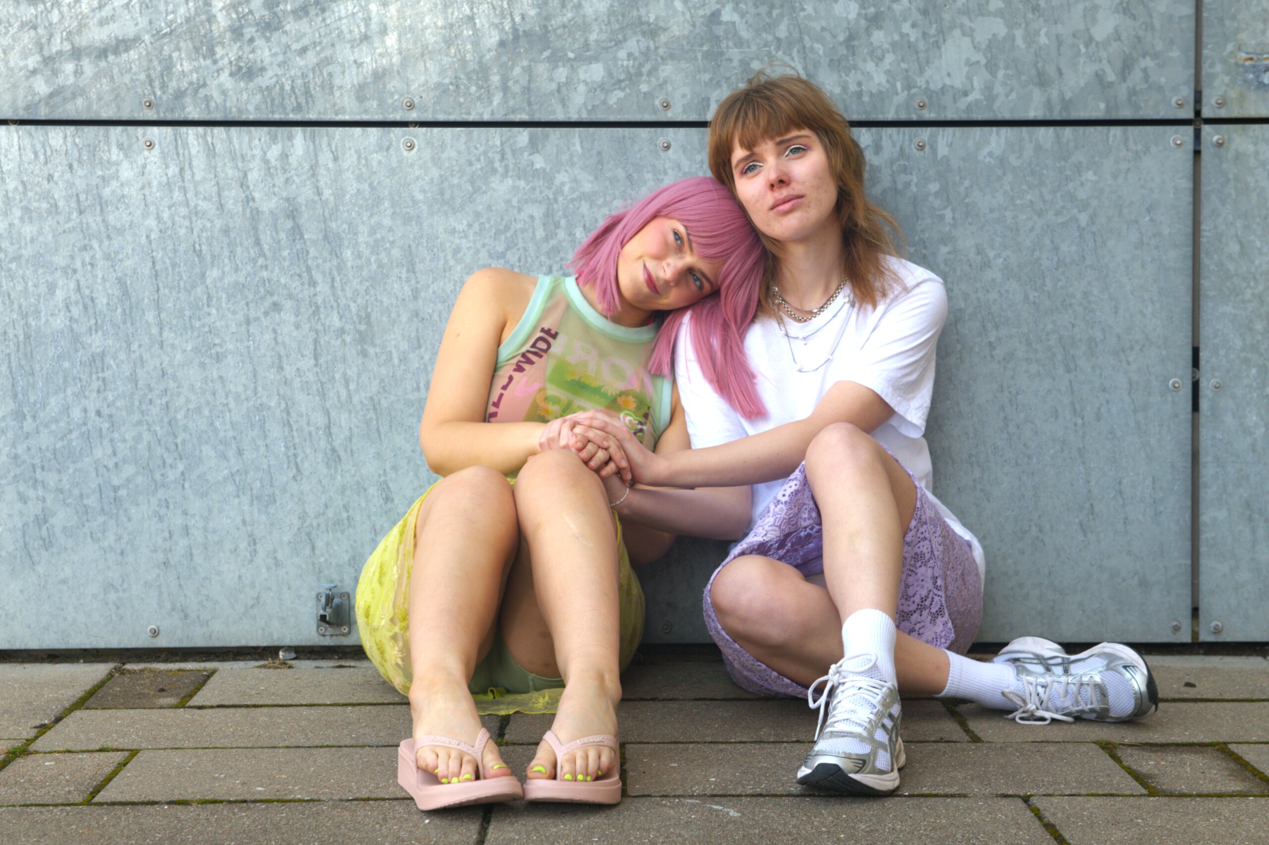 I romanen påtager hovedpersonen en ny identitet, da hun starter på gymnasiet. Hun farver sit hår pink og skifter navn for at passe ind. Her ses forestillingens hovedrolleindehaver Line Weien Hoffmann til venstre og manuskriptforfatteren til højre.