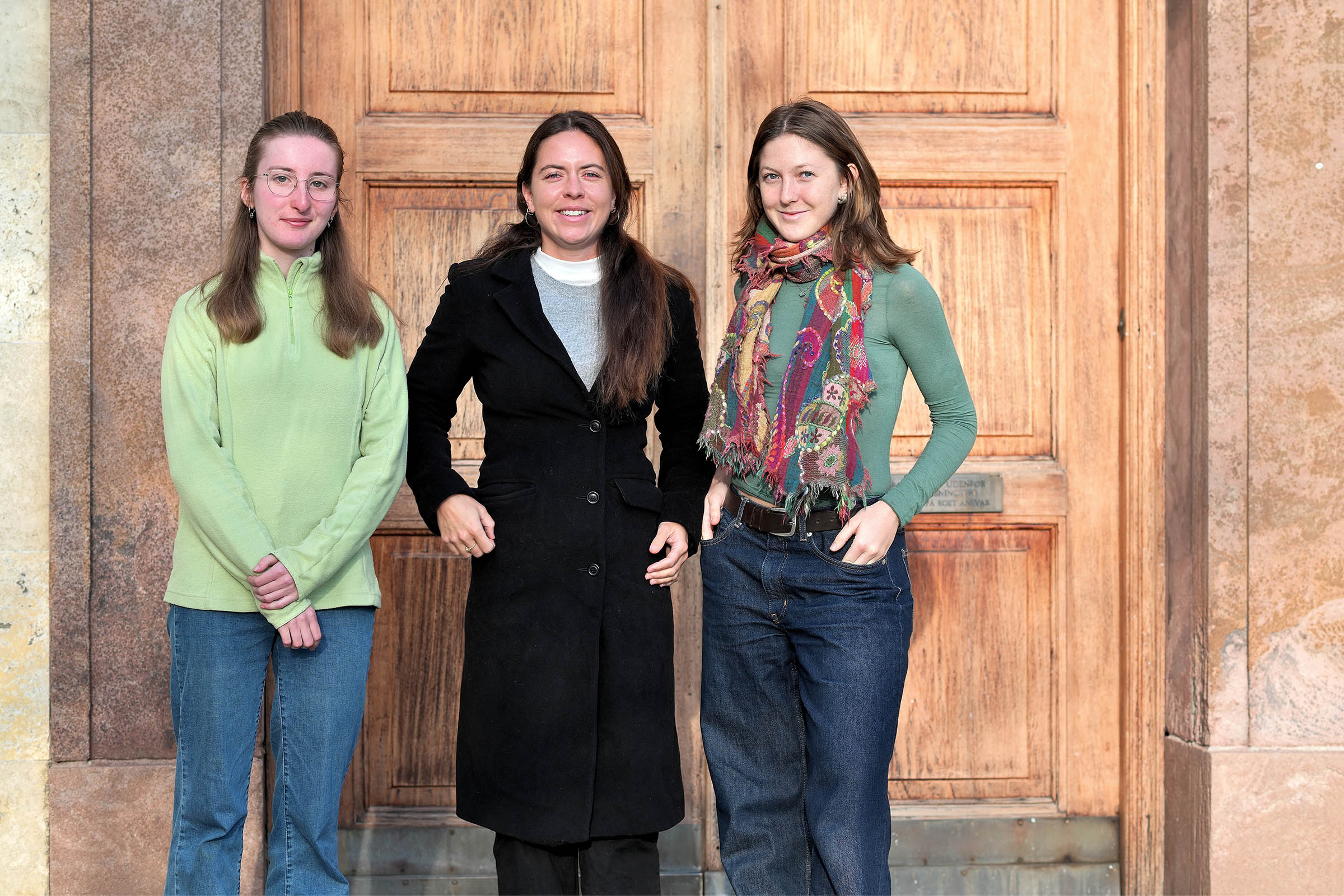 Fra venstre mod højre er det: Lucie Blackmore, Eluise Lenson og Maia Curti, her foran indgangen til Københavns Universitetsbibliotek i Universitetsparken. 