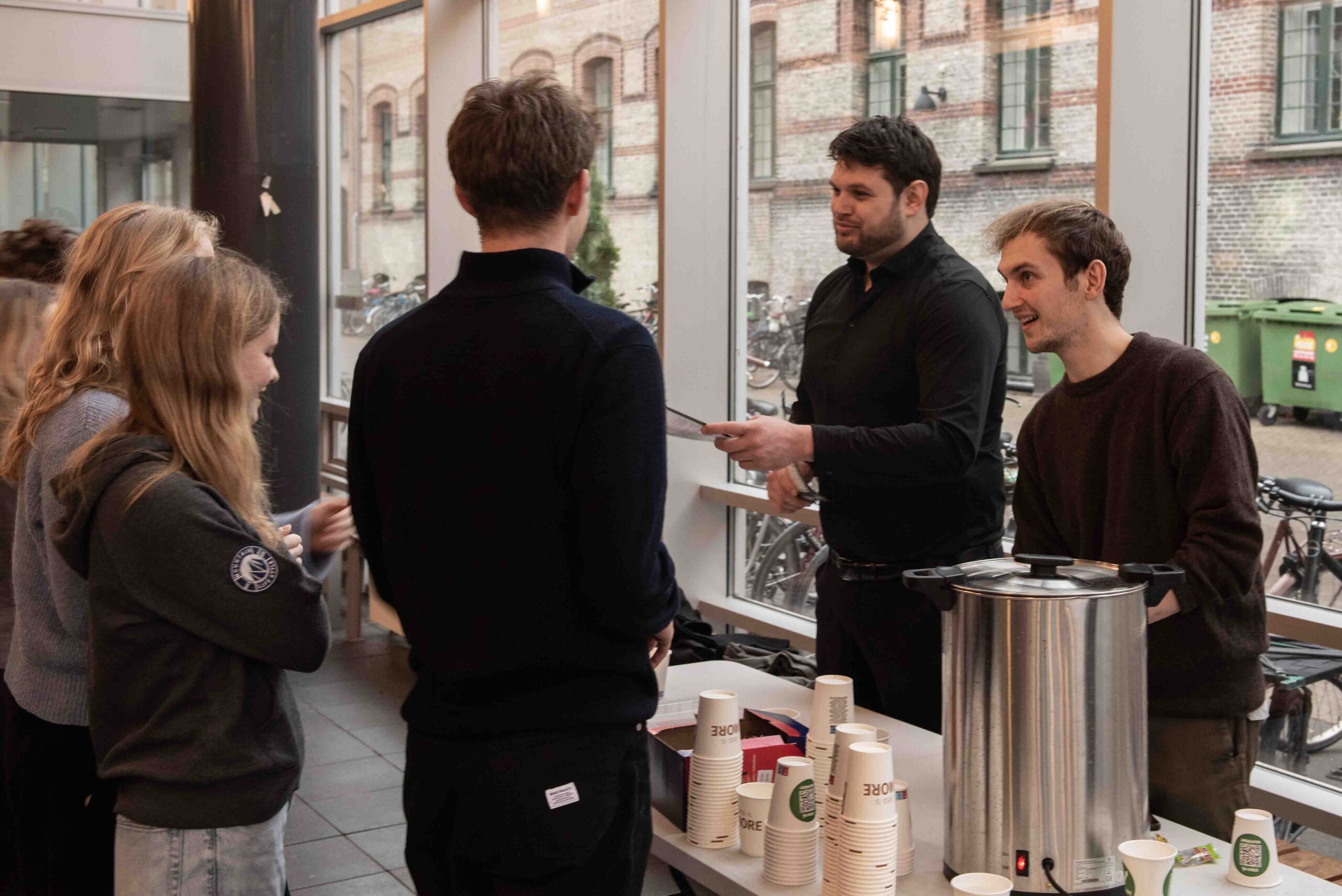 Formand for Politrådet, Mikkel Rahbek (th), og spidskandidat til bestyrelsen Christian Ramon (tv) deler valgkampens sidste kaffe ud.