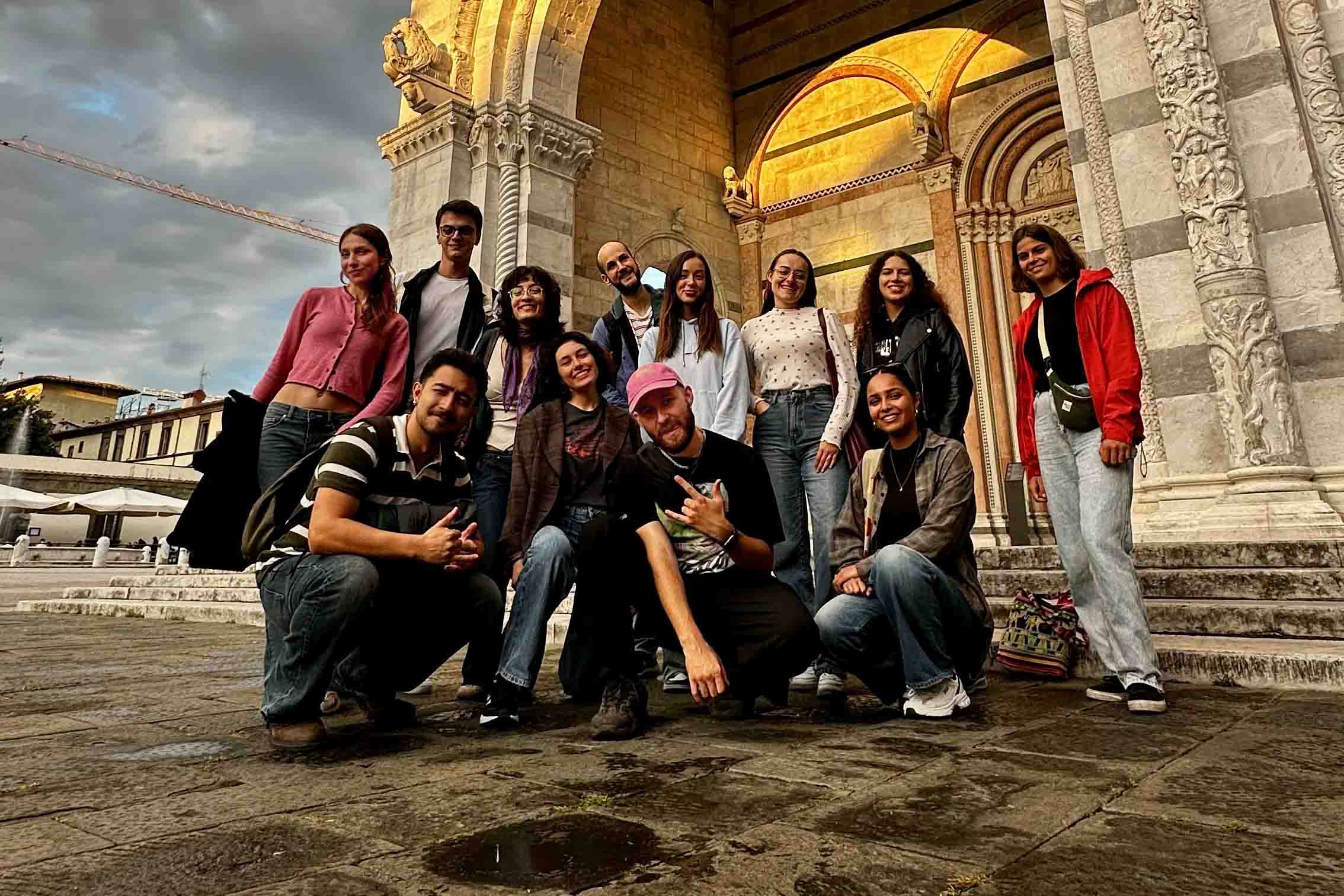 Foto fra introturen med de andre udvekslingsstuderende i byen Lucca i Italien. Skribenten knæler i midten iført en lyserød cap.