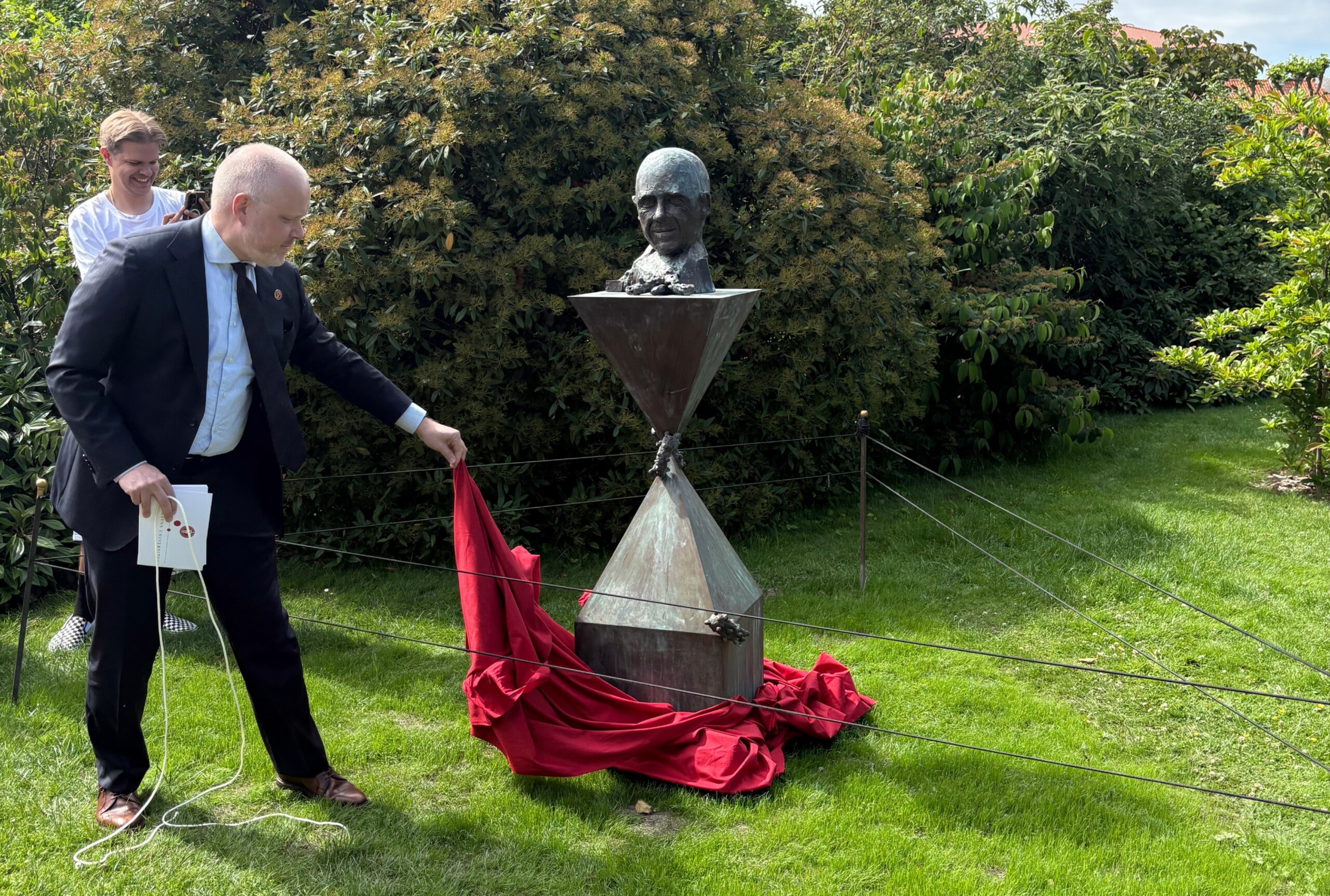 Ved afsløringen dvæler David Dreyer Lassen ved soklens udformning og siger, at han i konstruktionen genkender rollen som rektor, hvor man er overhoved for en omvendt pyramide, hvor meget bliver sat på spidsen, og at det slår gnister der, hvor de to pyramider mødes: »Kantede, skarpe, spidse. Sætninger der møder modsætninger. Derfor er det både vidunderligt og besværligt at være rektor og forsker på KU.«