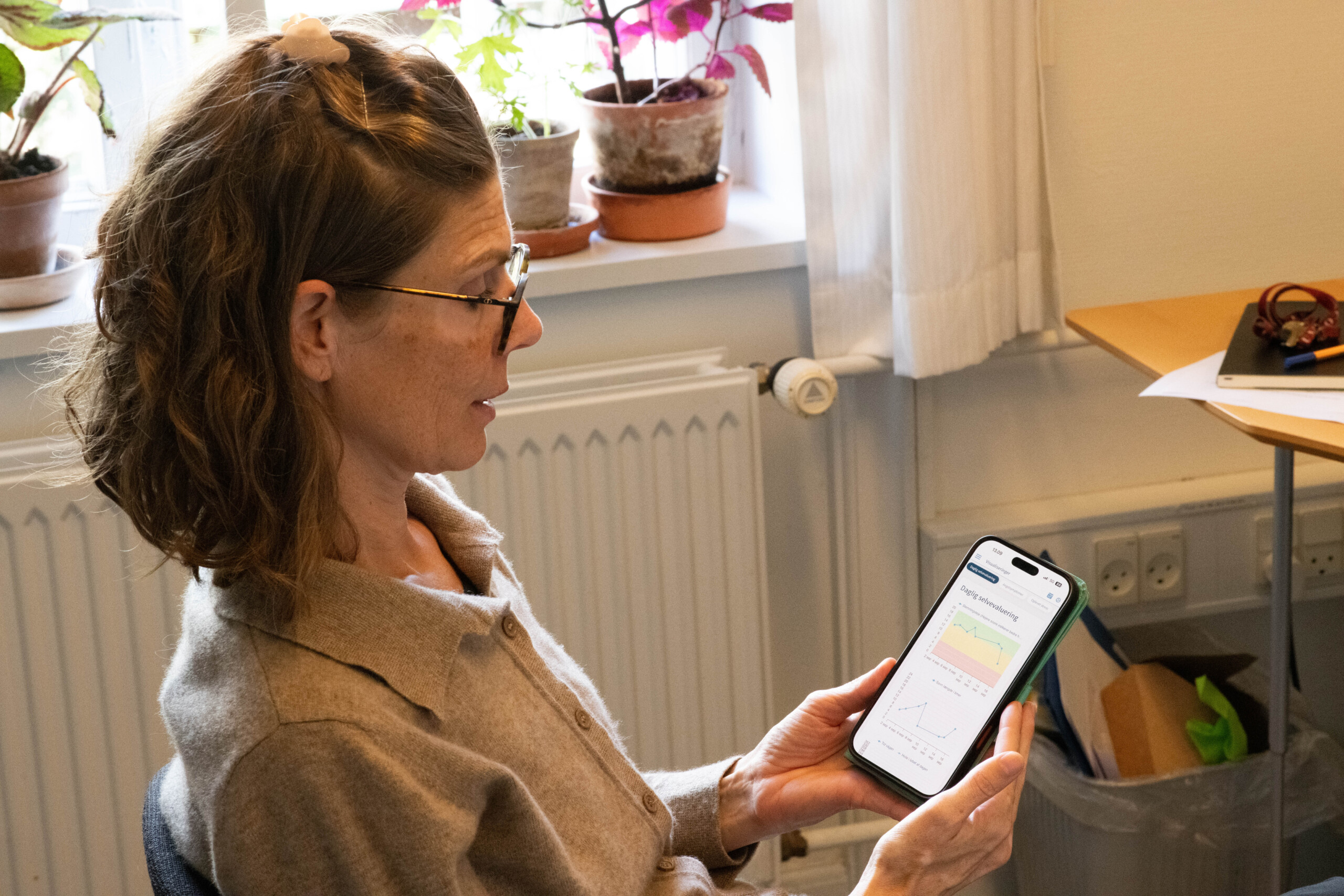 Daglige registreringer af blandt andet humør, søvn og aktivitet giver et mere detaljeret indblik i patienternes sygdomsforløb, og kan hjælpe lægerne med at give den korrekte behandling. På billedet viser Maria Faurholt-Jepsen en test-version af en af de apps, der indgår i hendes forskning.